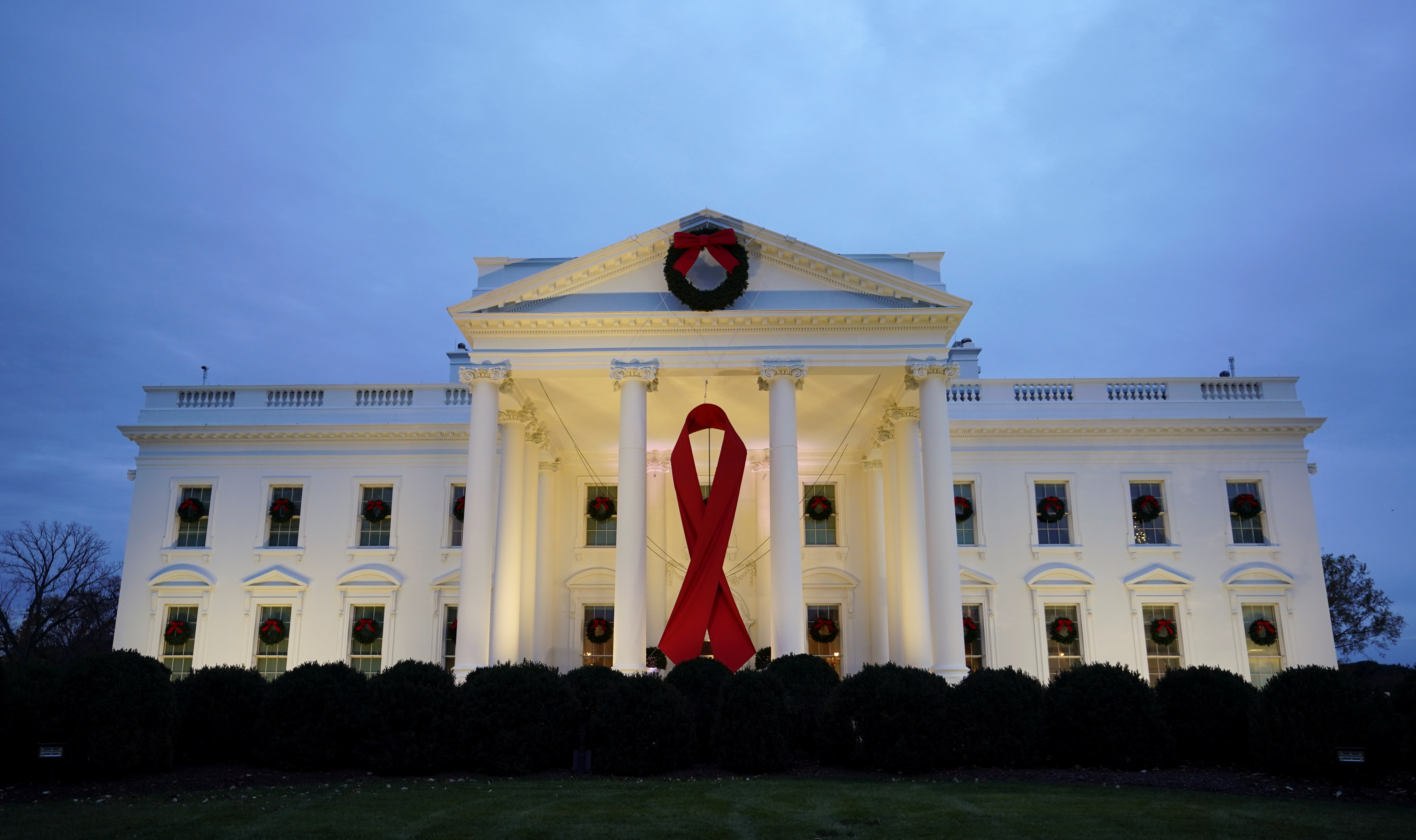 A red ribbon hangs on the North Portico of the White House on World AIDS Day in Washington