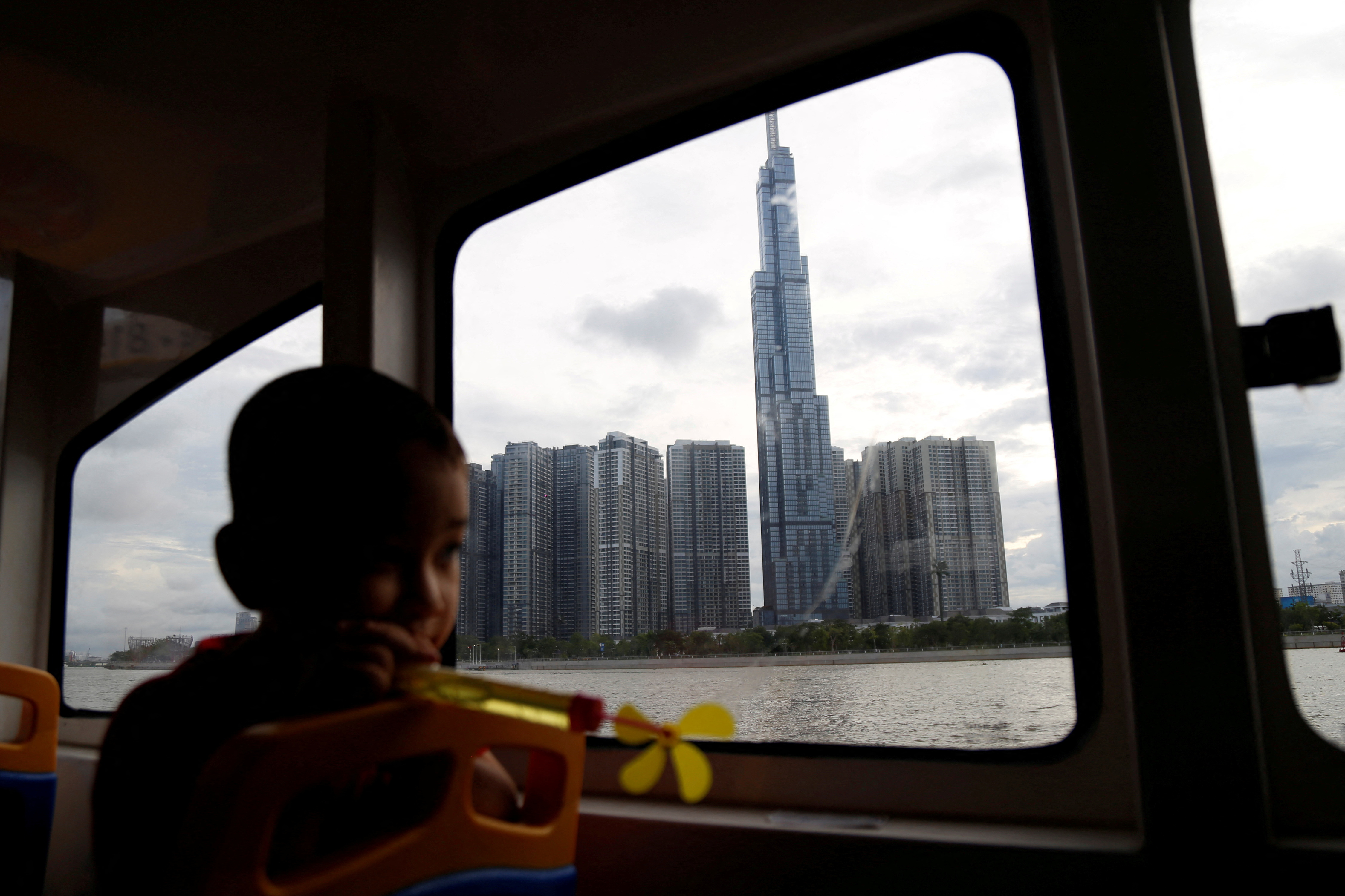 A boy is seen inside a Saigon waterbus, overlooking Landmark 81, Vietnam's tallest building in Ho Chi Minh city