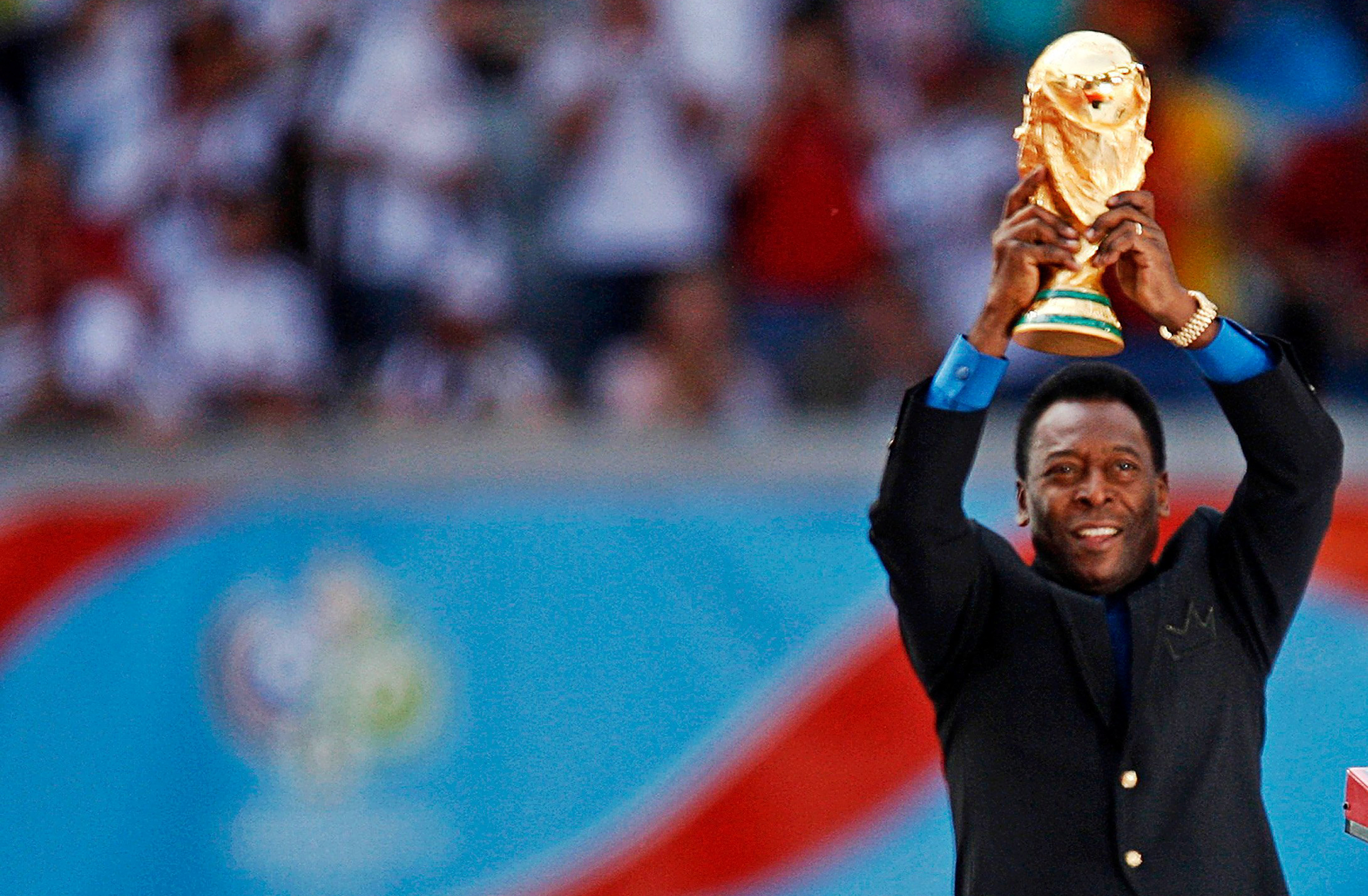 Brazilian football legend Pele holds the World Cup trophy at the opening ceremony of the 2006 World Cup in Munich.