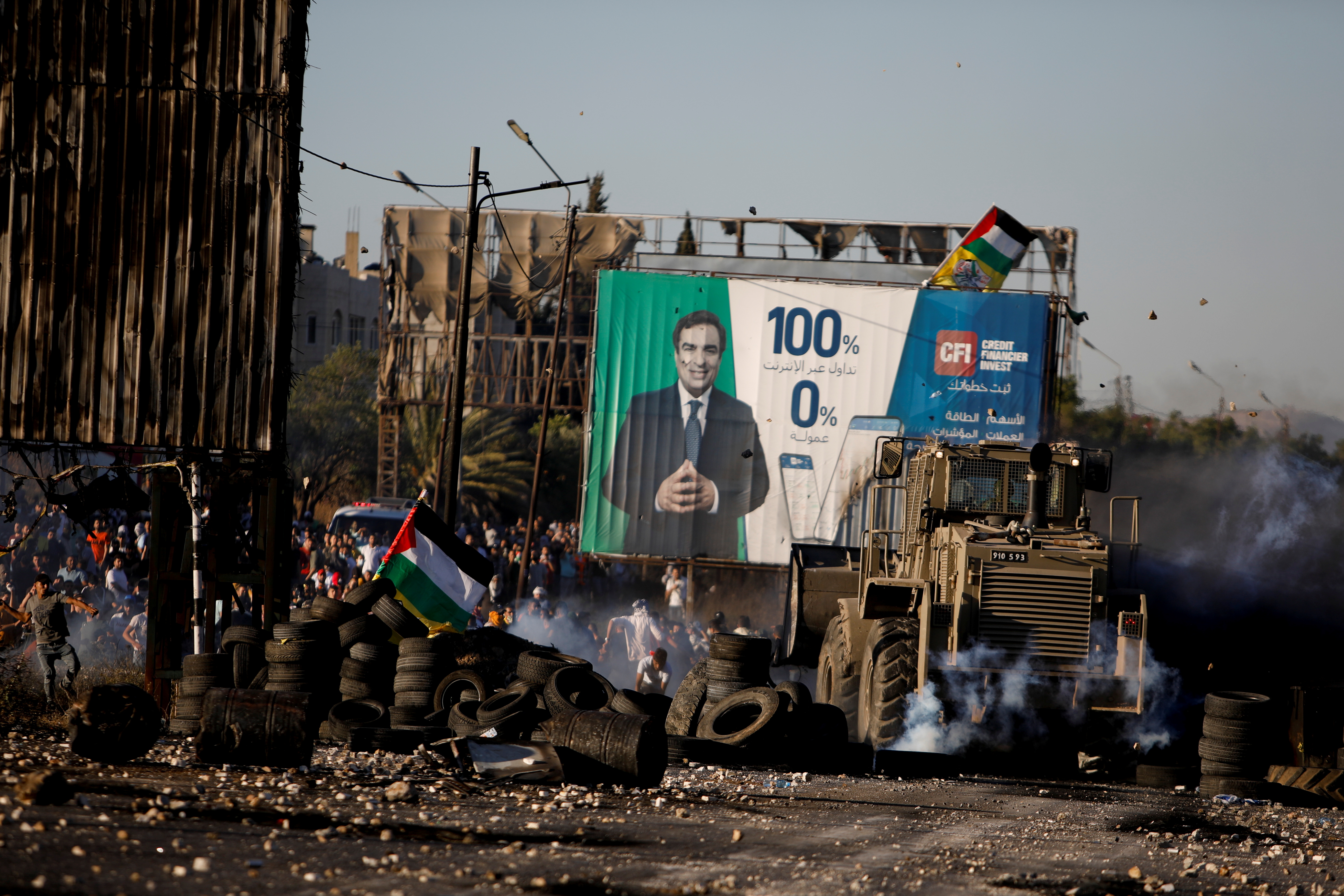 Des manifestants palestiniens jettent des pierres lors d'une manifestation anti-israélienne contre la violence transfrontalière entre les militants palestiniens à Gaza et l'armée israélienne, près du checkpoint de Hawara près de Naplouse en Cisjordanie occupée par Israël, le 18 mai 2021. REUTERS / Raneen Sawafta