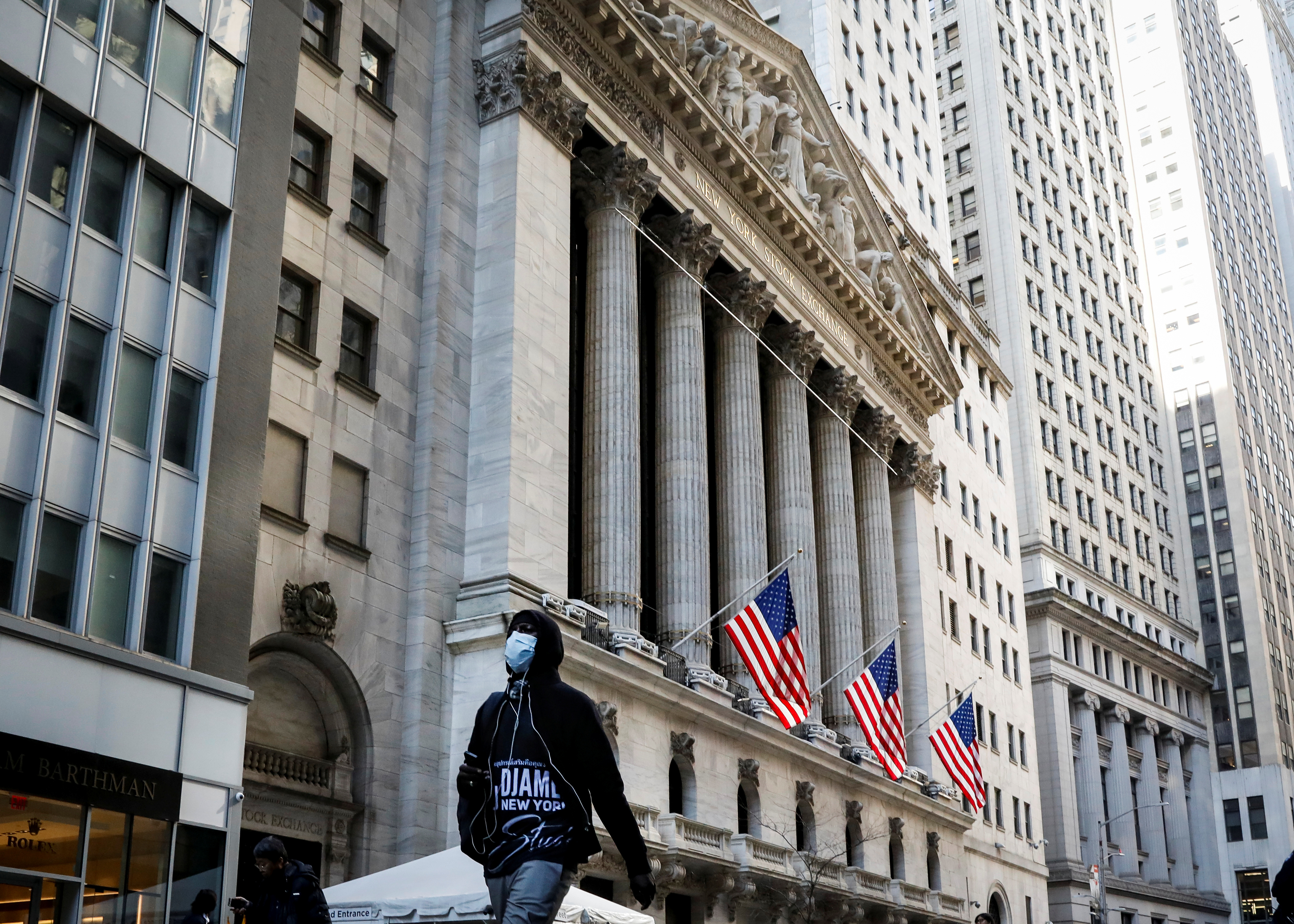 A man wears a mask as he walks near the New York Stock Exchange (NYSE) in the financial district in New York City, U.S., March 2, 2020. REUTERS/Brendan McDermid
