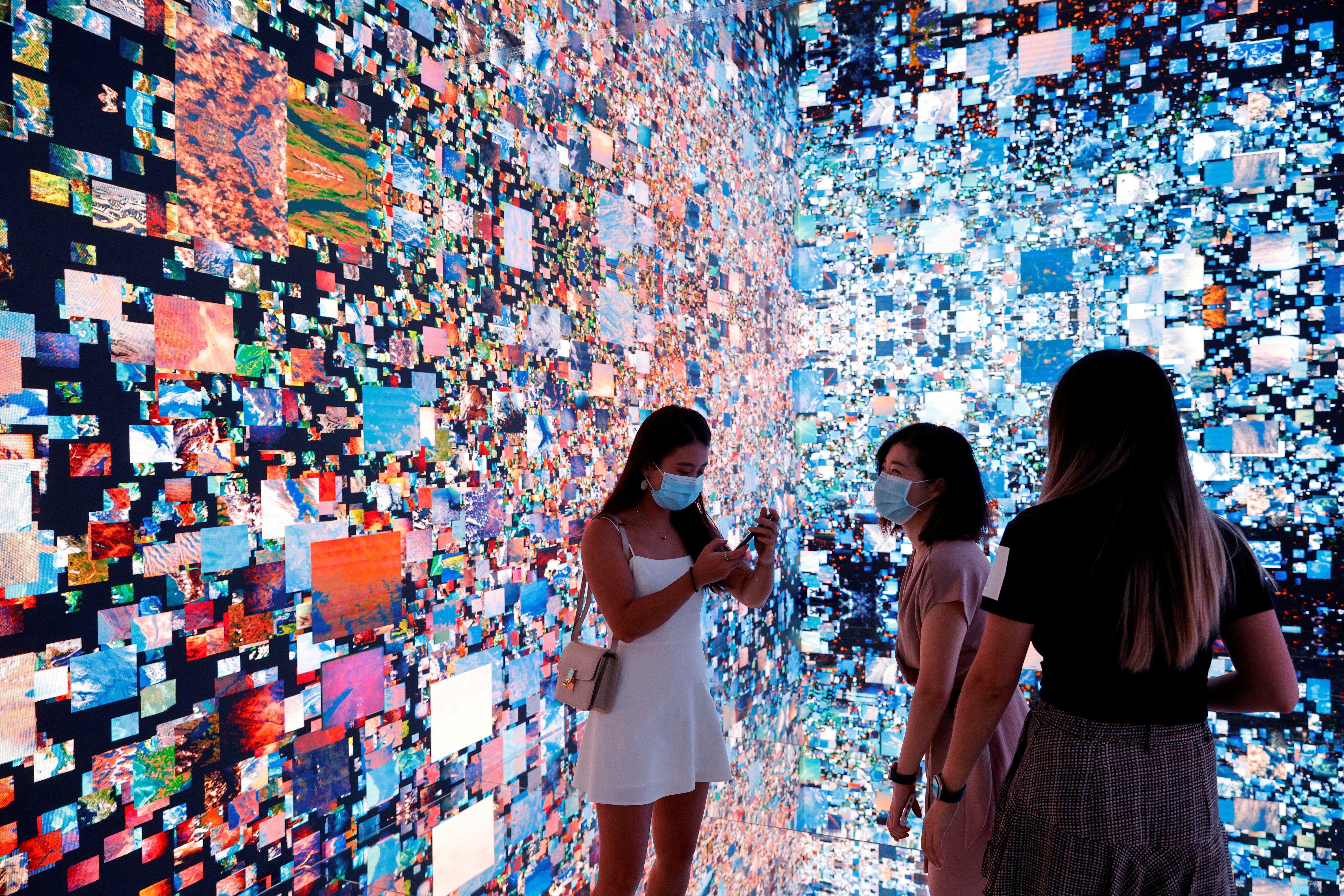 File photo: visitors are pictured in front of an immersive art installation titled "machine hallucinations — space: metaverse" by media artist refik anadol, which will be converted into nft and auctioned online at sotheby's, at the digital art fair, in hong kong, china september 30, 2021. Reuters/tyrone siu