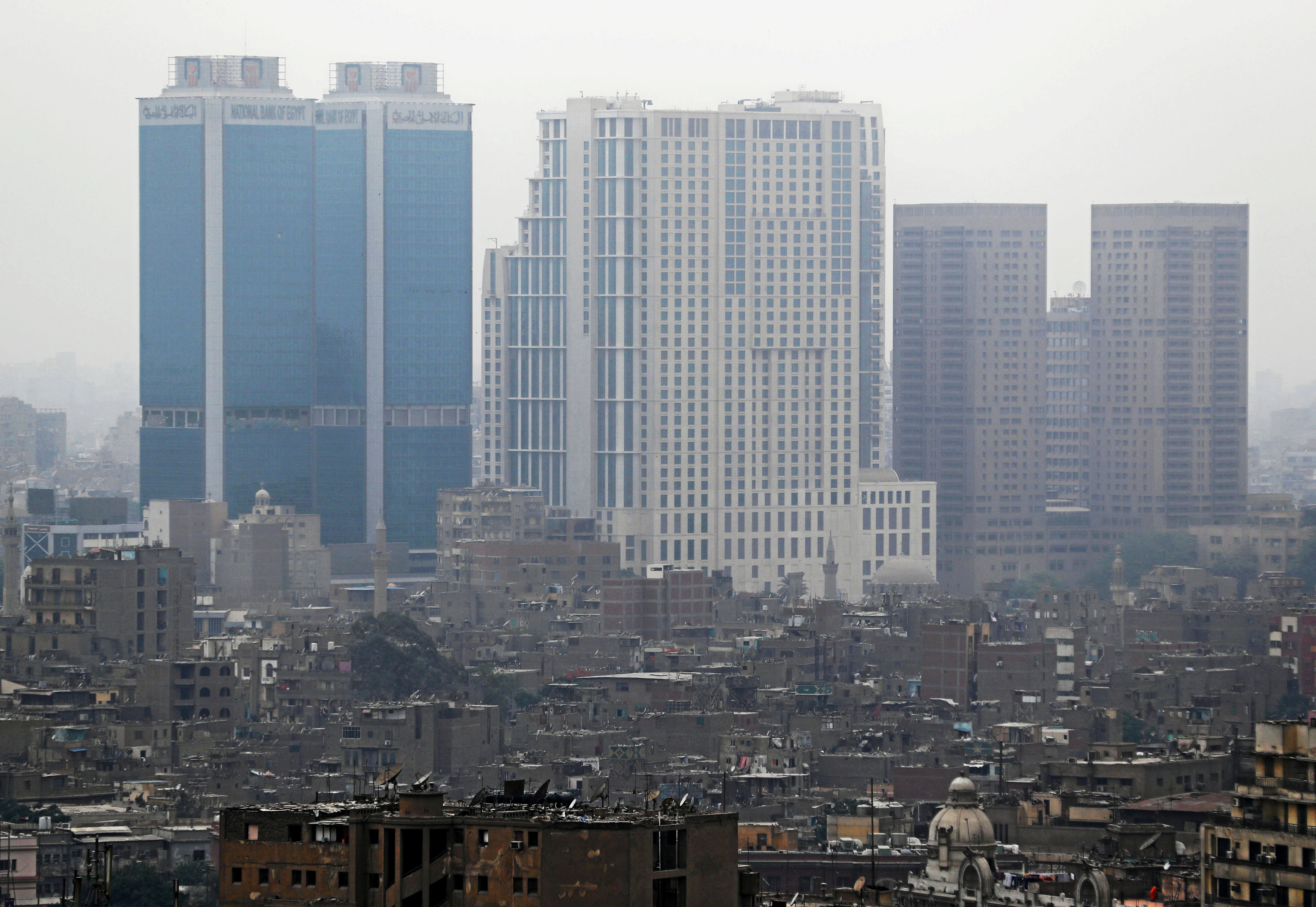National Bank of Egypt head offices, the St. Regis Cairo hotel and Hilton Cairo World Trade Center Residences are seen towering above residential buildings in the downtown Cairo