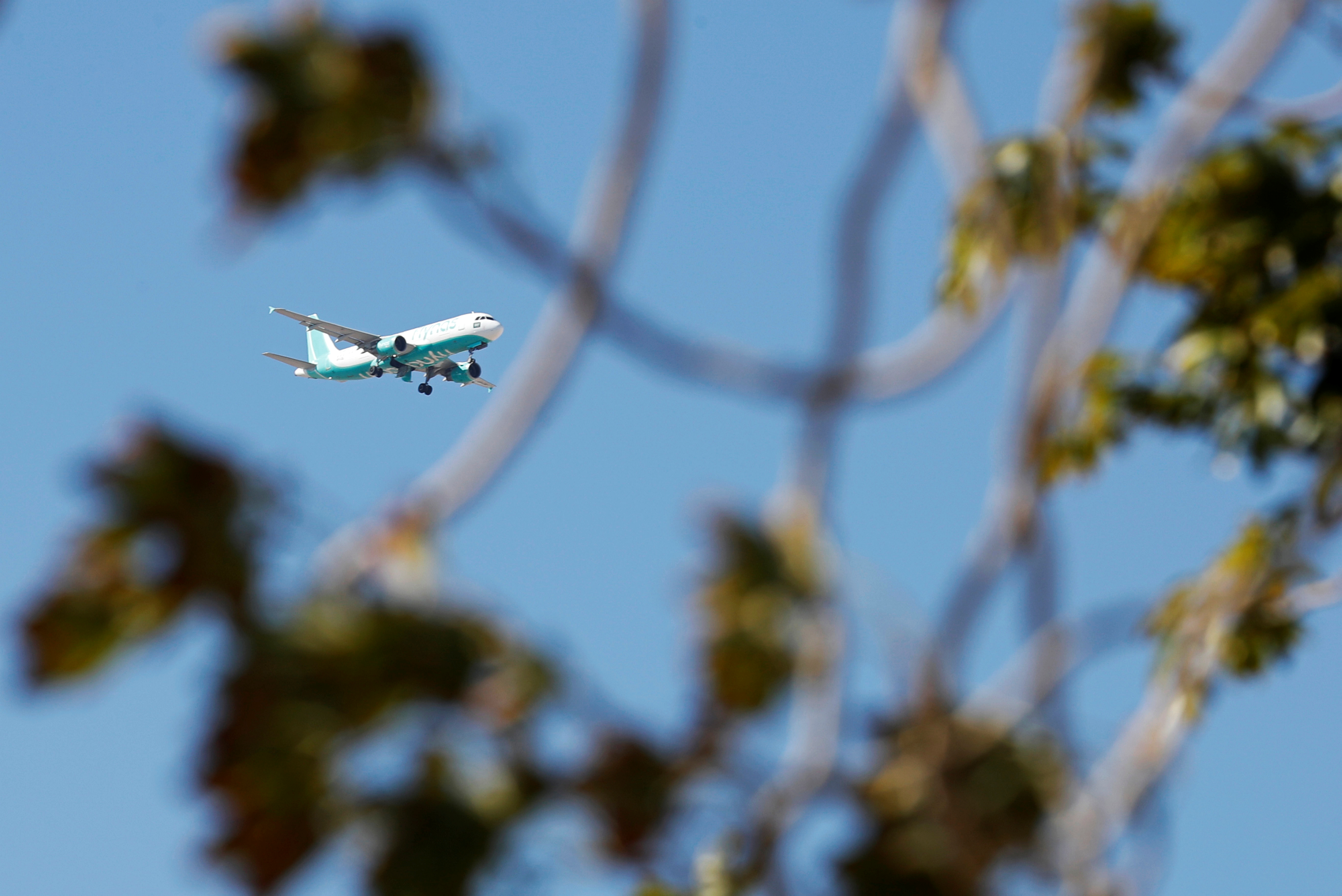 A Saudi budget airline Flynas Airbus A320 plane flies over the Red Sea resort of Sharm el-Sheikh, south of Cairo