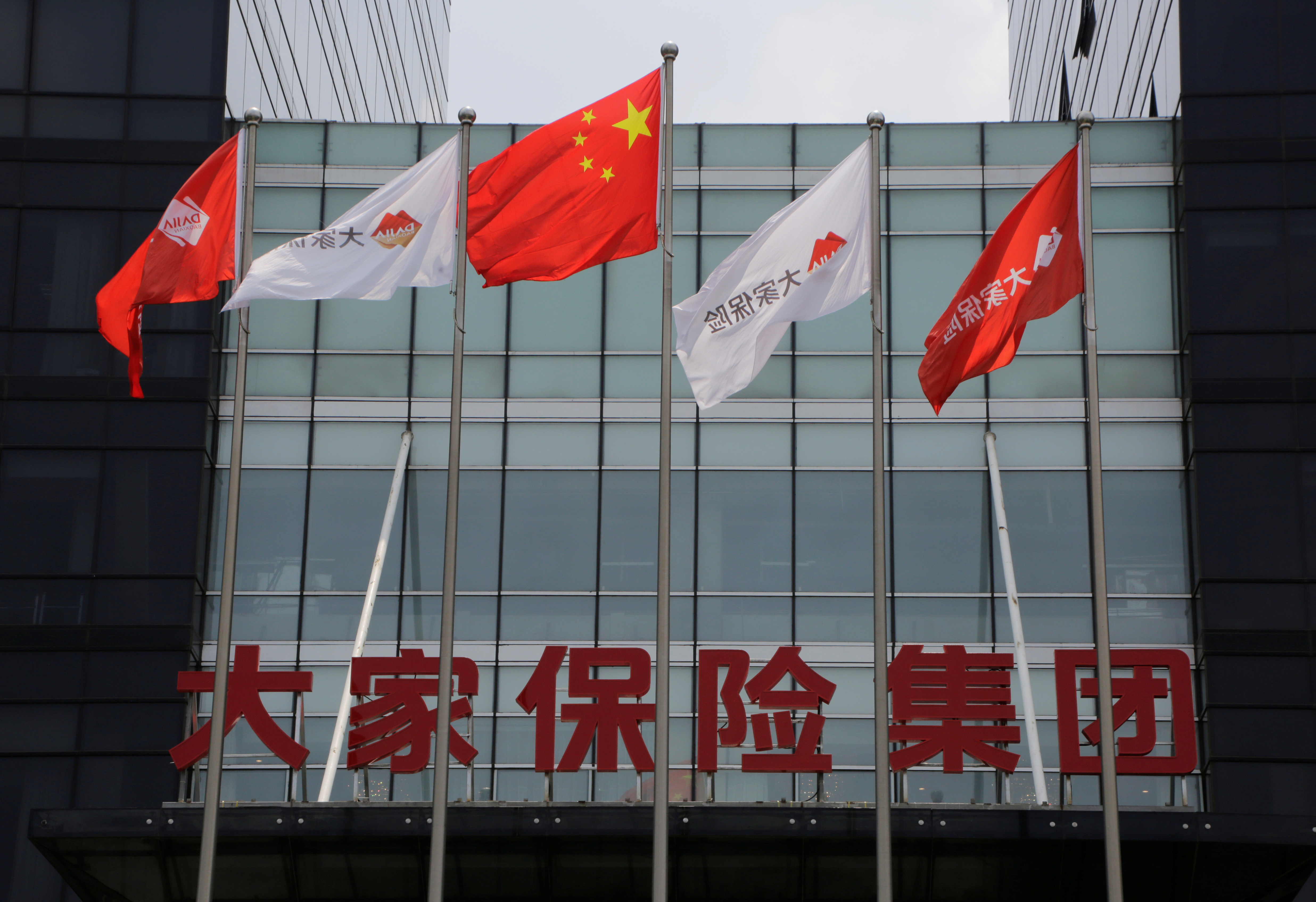 Company flags and the sign of Dajia Insurance Group are seen at the former headquarters of Anbang Insurance Group, in Beijing, China, July 11, 2019. REUTERS/Jason Lee