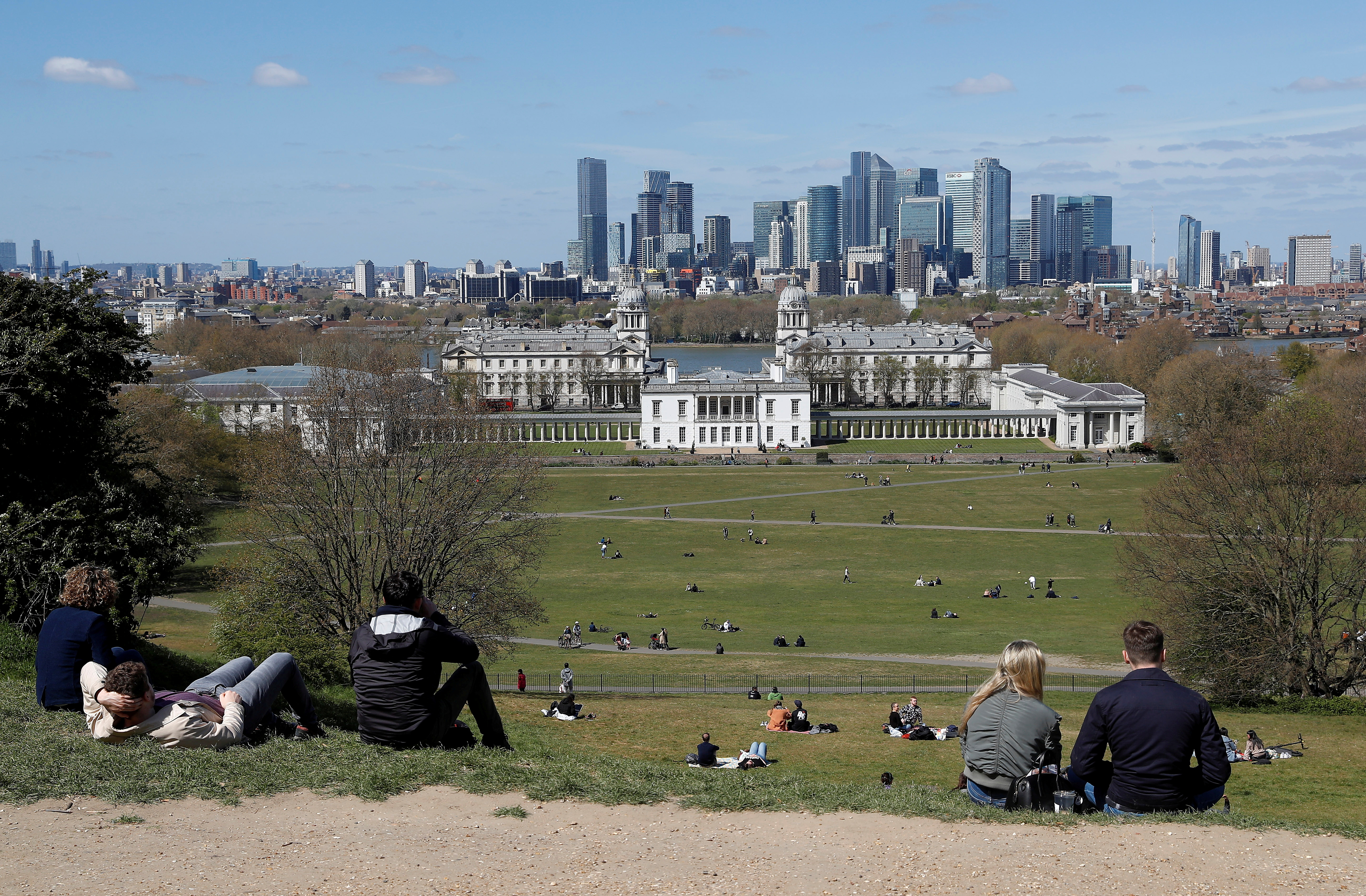 Visitors to Greenwich Park sit and look towards Canary Wharf financial district as lockdown restrictions are eased amidst the spread of the coronavirus disease (COVID-19) pandemic in London