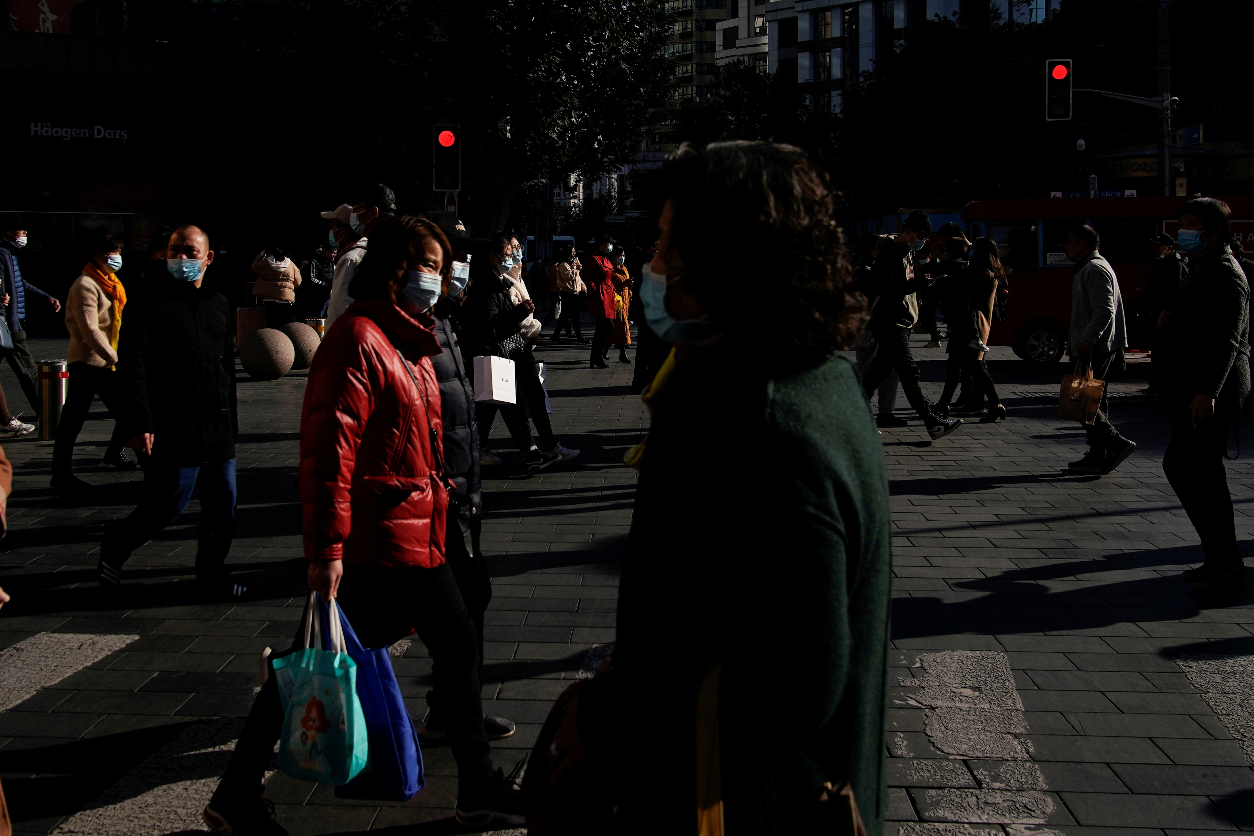  People wearing protective masks walk on a street, following new cases of the coronavirus disease (COVID-19), in Shanghai, China, November 24, 2021. REUTERS/Aly Song/File Photo