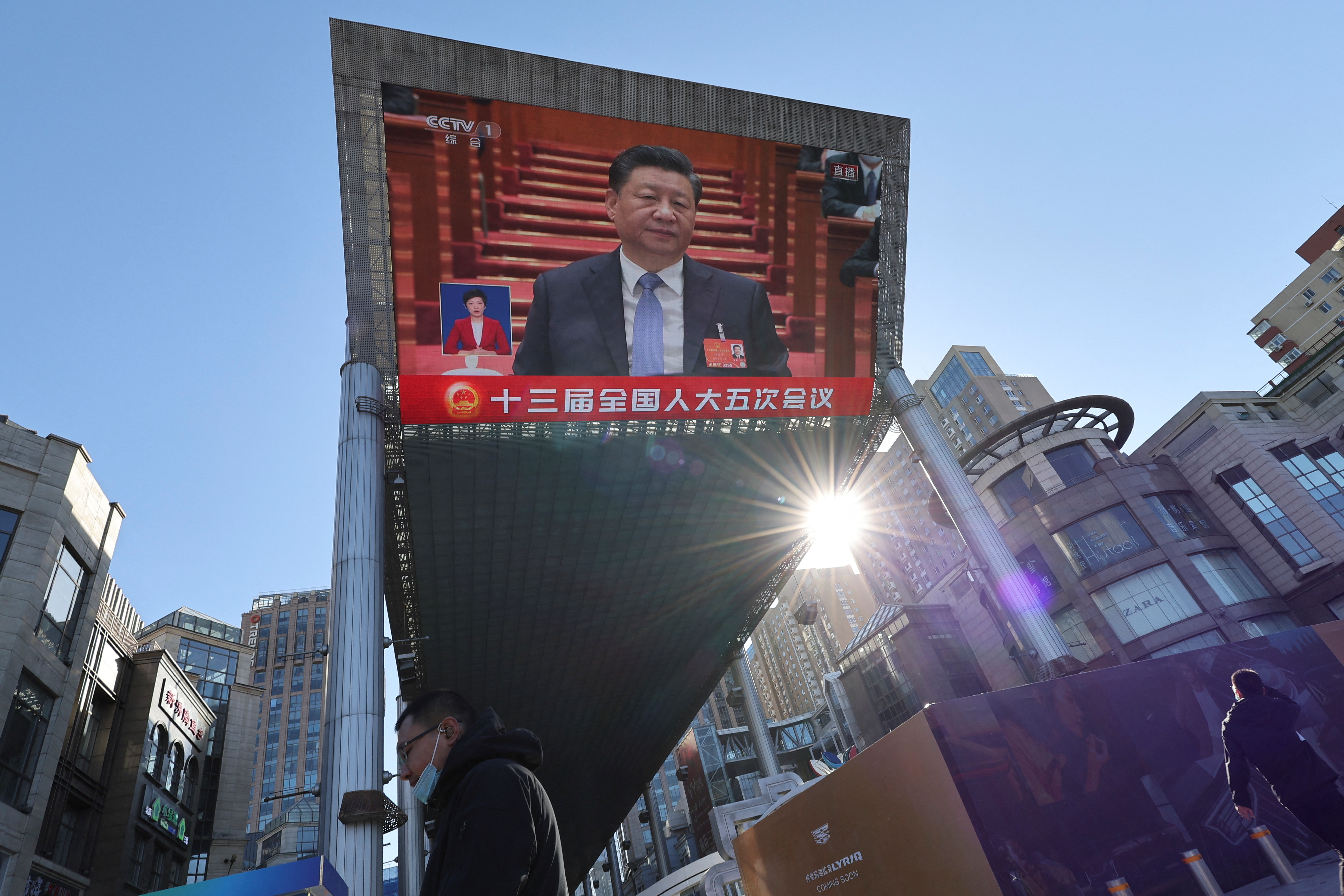 Giant screen shows Chinese President Xi Jinping attending the opening session of the National People's Congress (NPC) at the Great Hall of the People, in Beijing