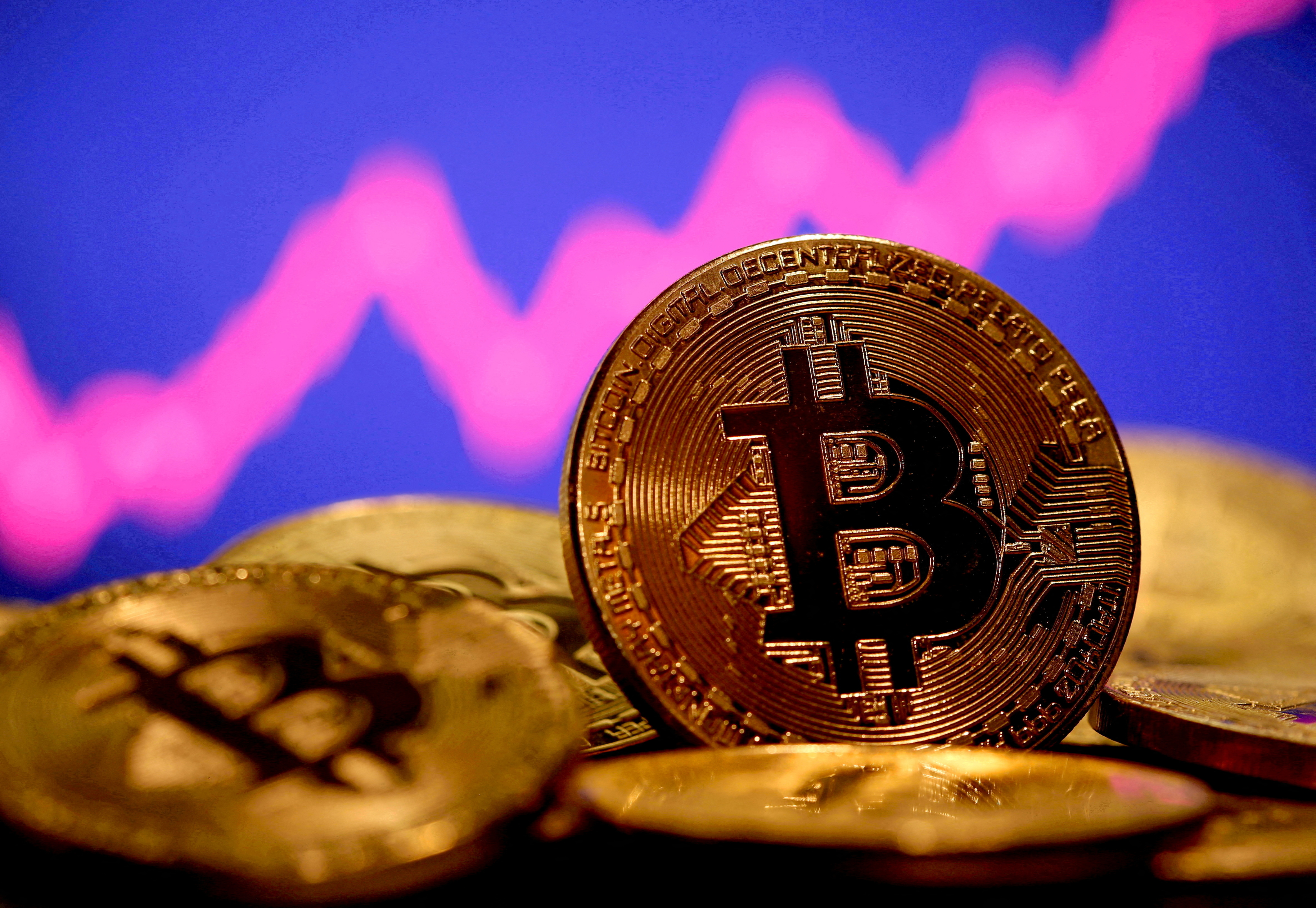 FILE PHOTO: A representation of virtual currency Bitcoin is seen in front of a stock graph in this illustration