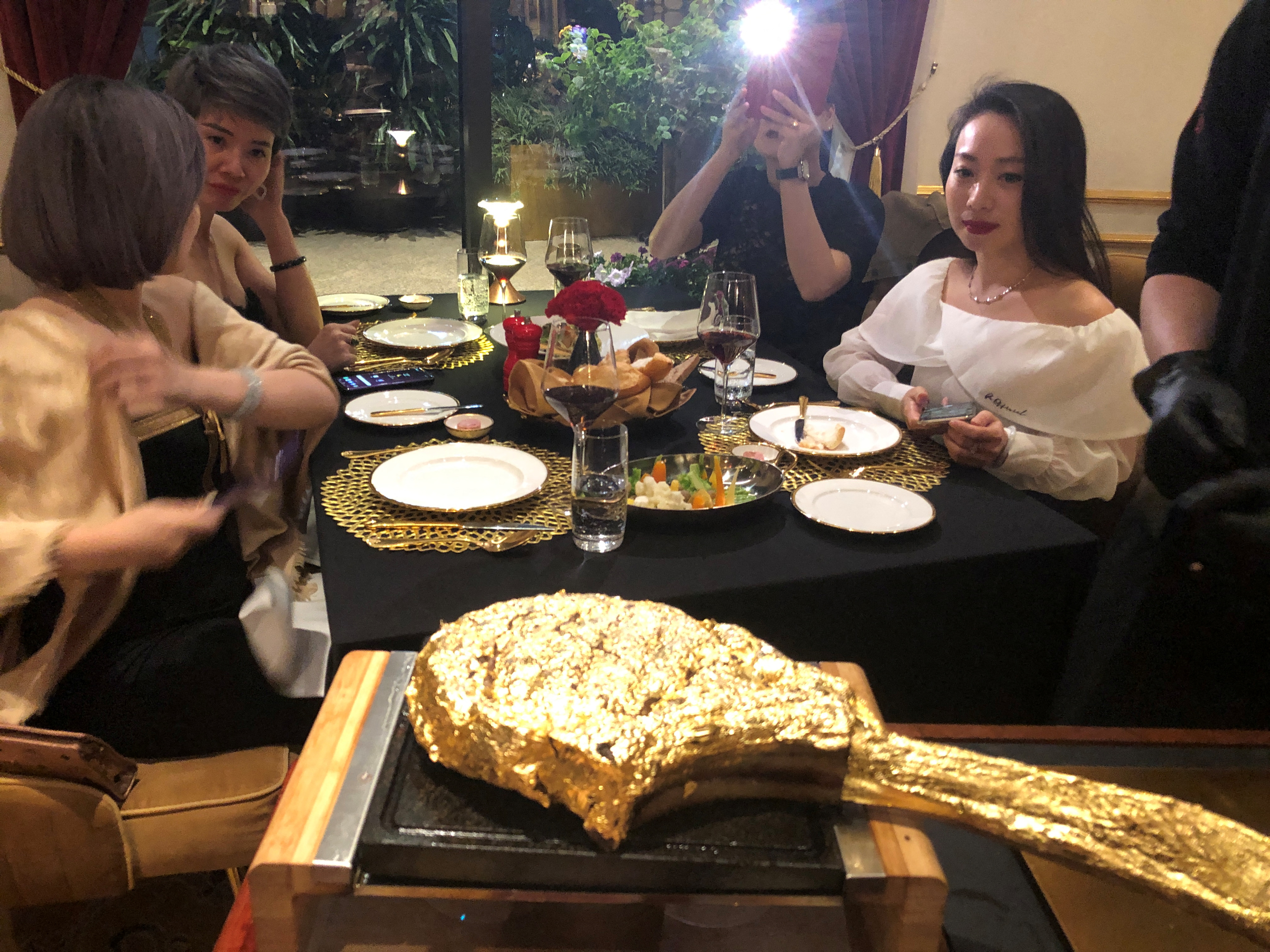 A customer takes pictures of a gold leaf-coated steak, at a Dolce By Wyndham Hanoi Golden Lake hotel, in Hanoi