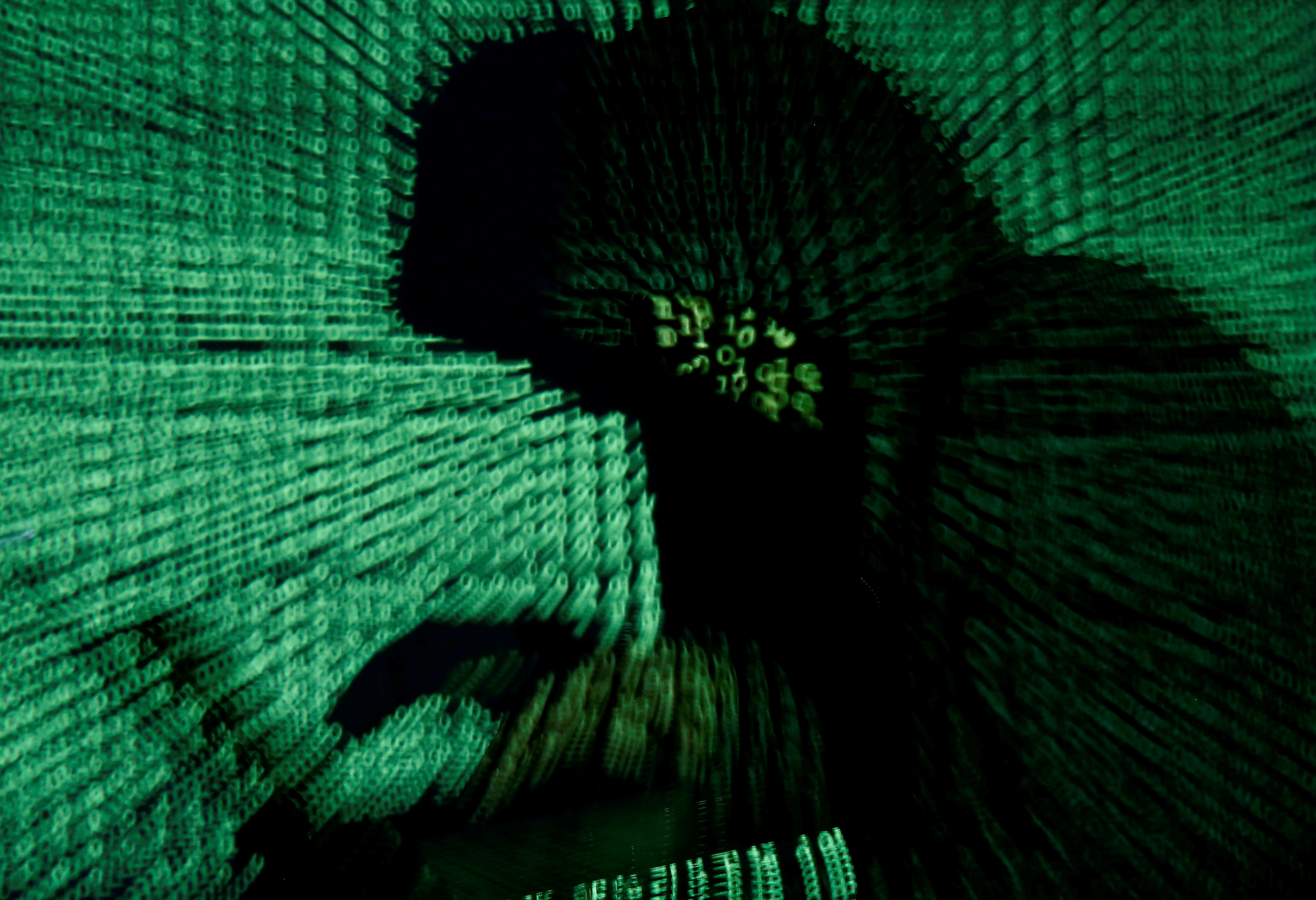 A man holds a laptop computer as cyber code is projected on him in this illustration picture taken on May 13, 2017. REUTERS/Kacper Pempel/File Photo