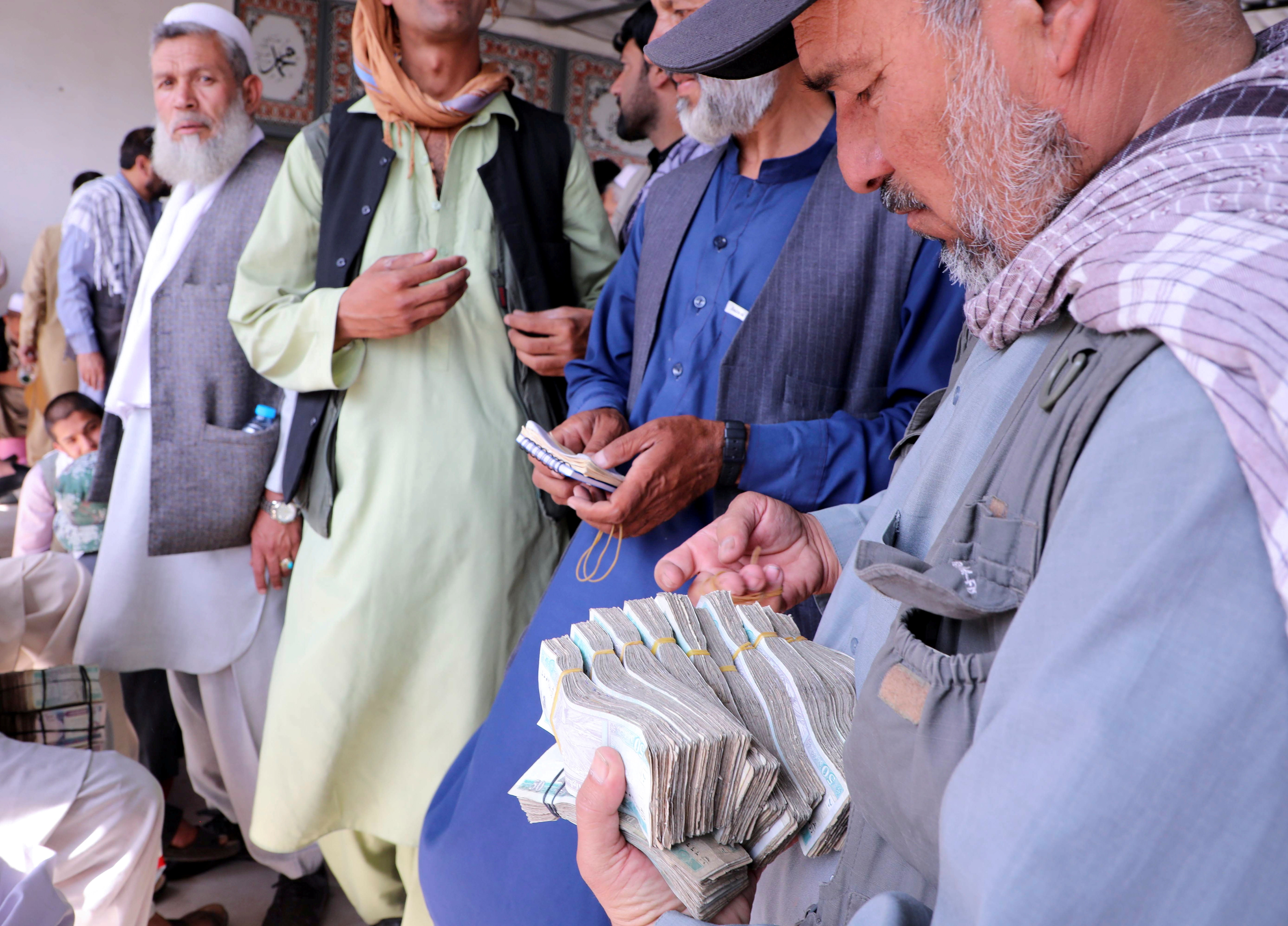Afghan money exchange dealers wait for customers at a money exchange market in Kabul