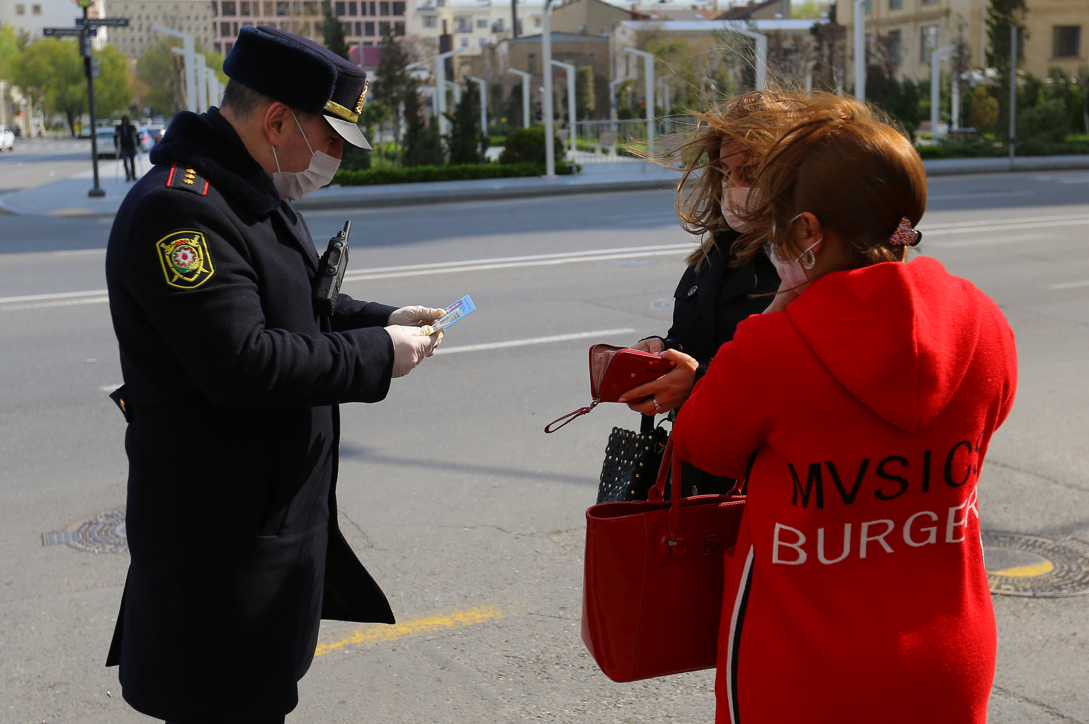 An Azeri law enforcement officer checks documents of women in Baku