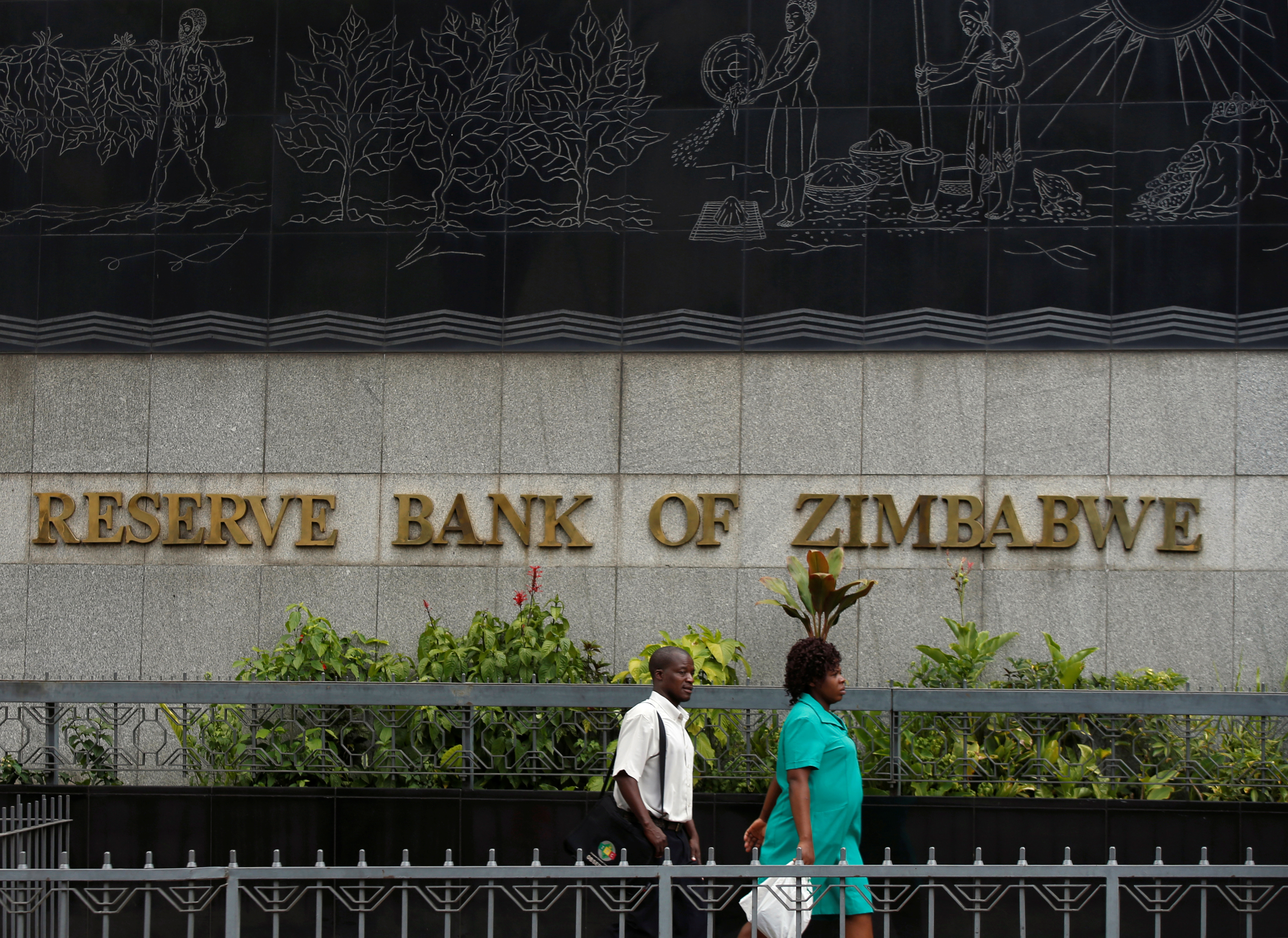 People walk past the Reserve Bank of Zimbabwe building in Harare, Zimbabwe, February 25, 2019. REUTERS/Philimon Bulawayo