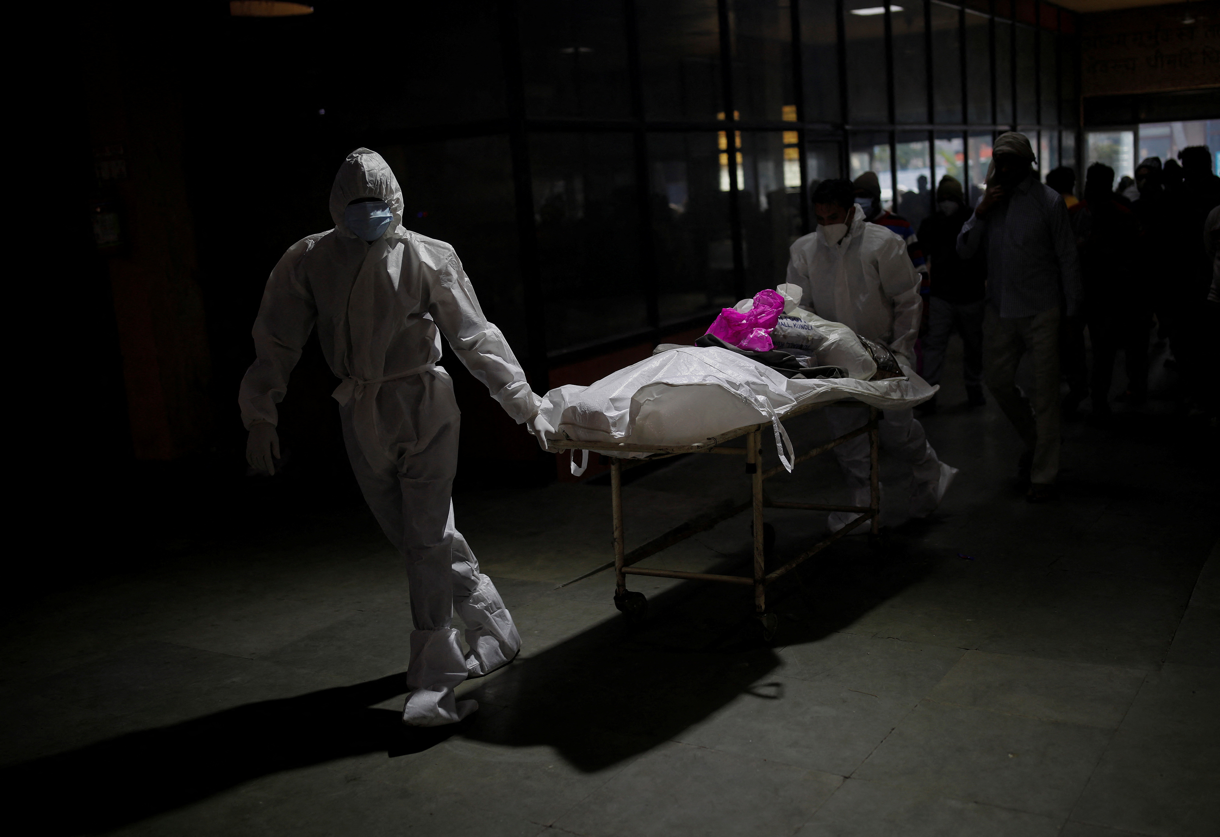 Health workers wearing personal protective equipment (PPE) carry the body of Ramdhan, who died from the coronavirus disease (COVID-19), before his cremation, at a crematorium in New Delhi