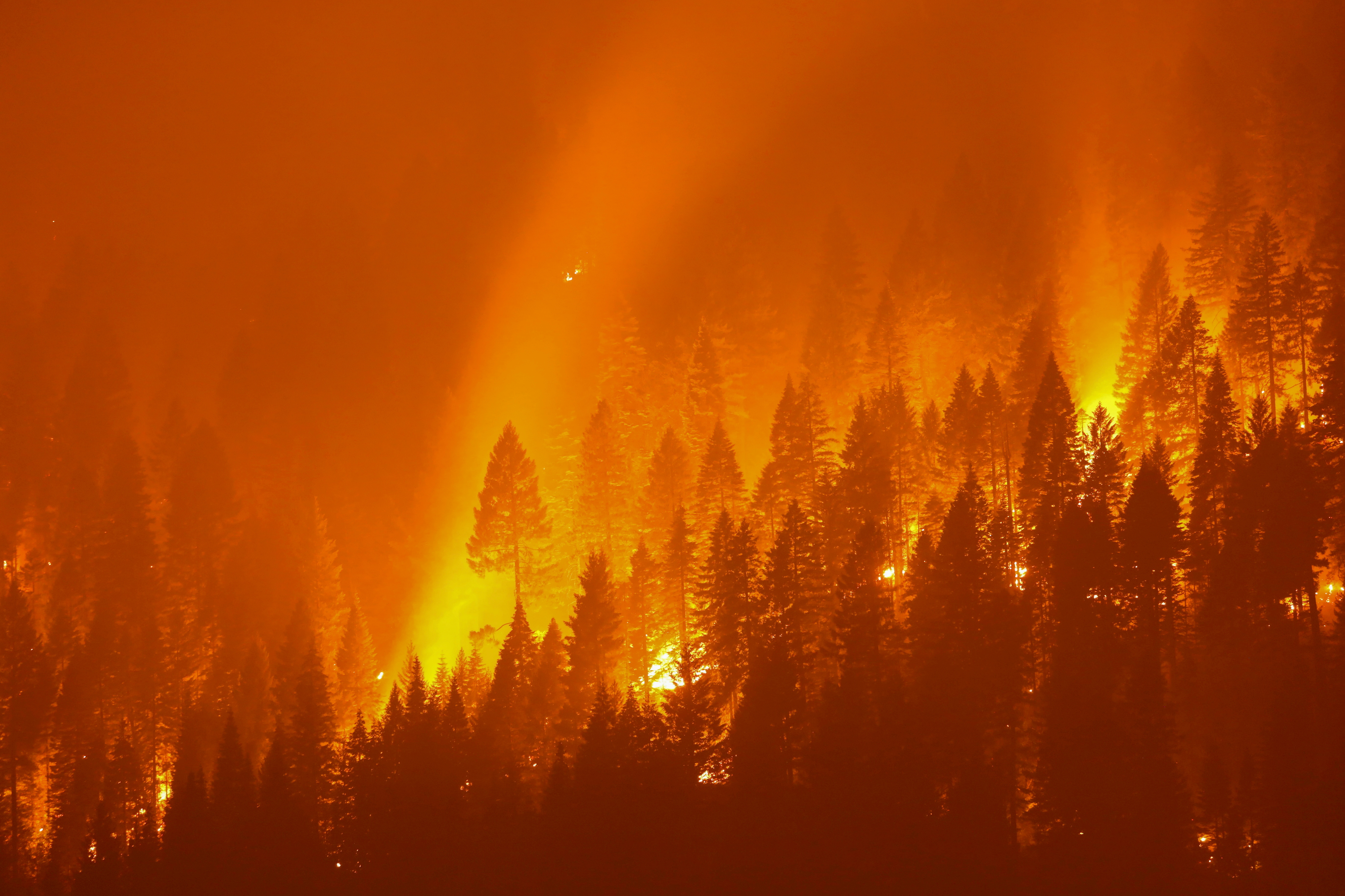 The Dixie Fire, California’s largest active fire burns at night in Taylorsville