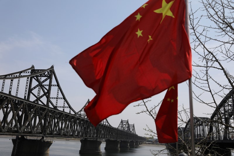 Chinese national flag flutters near the Friendship Bridge and Broken Bridge over the Yalu River, in Dandong