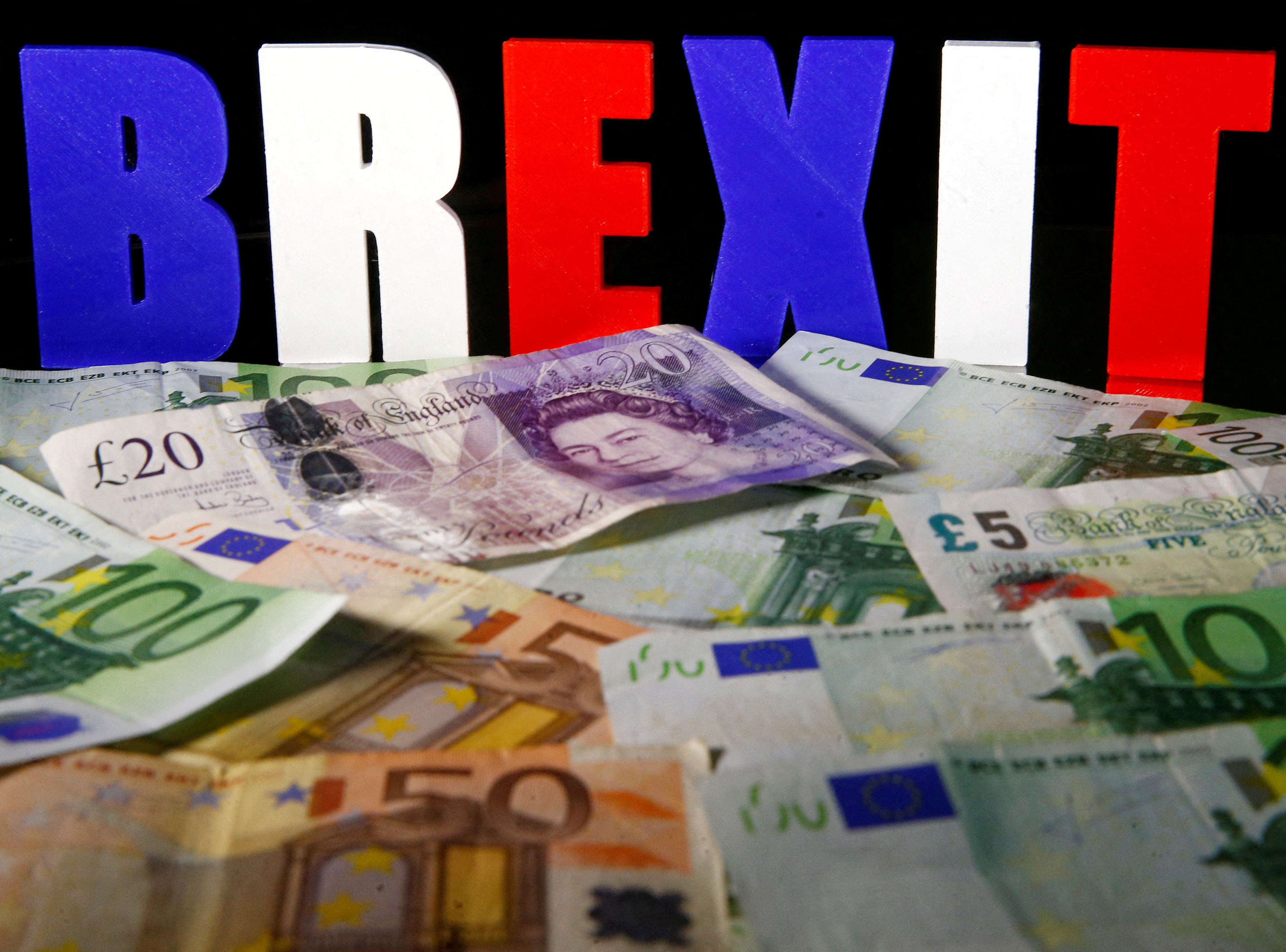 Euro and Pound banknotes are seen in front of BREXIT letters in this picture illustration