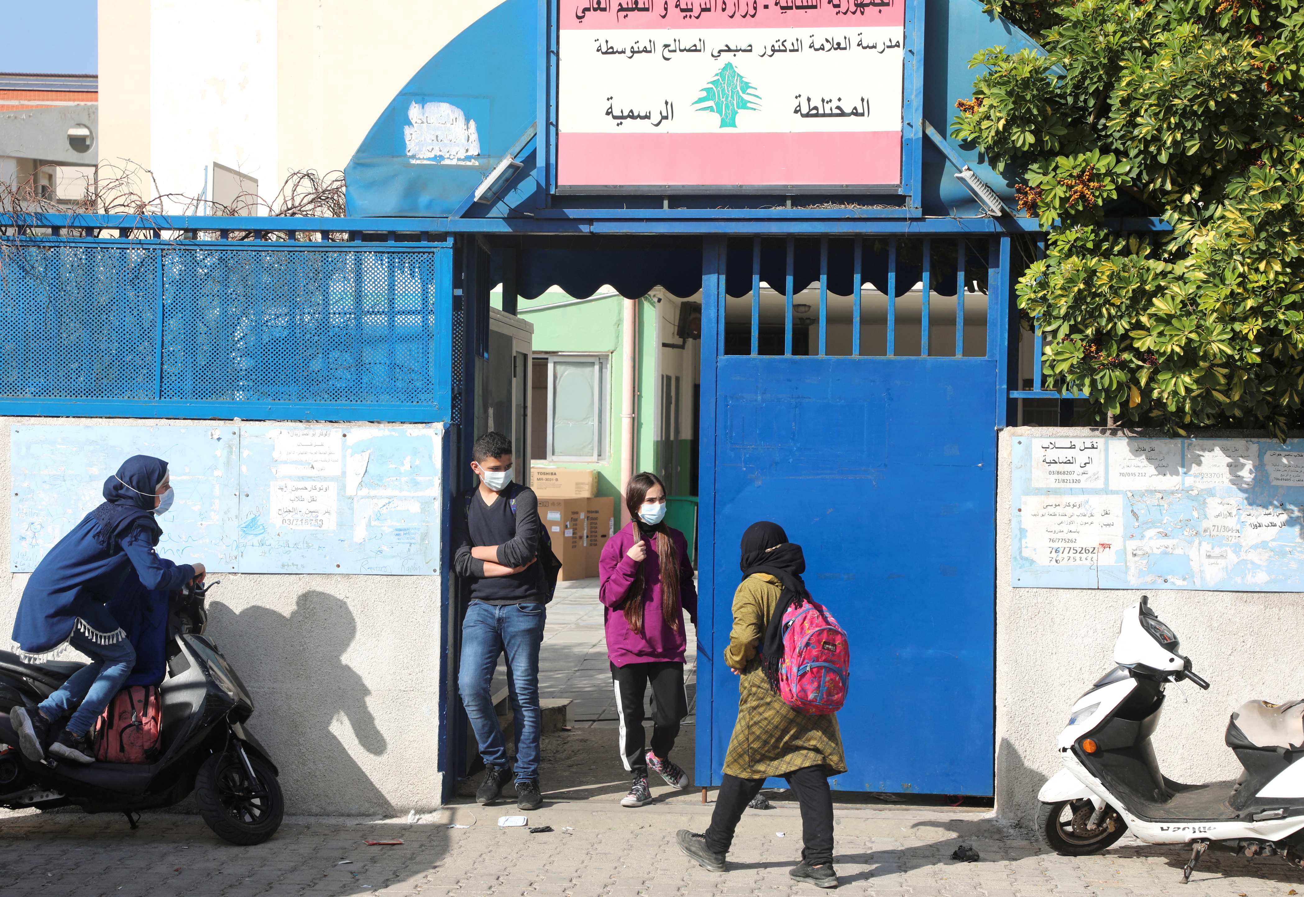 Students walk at the entrance of a public school in Beirut