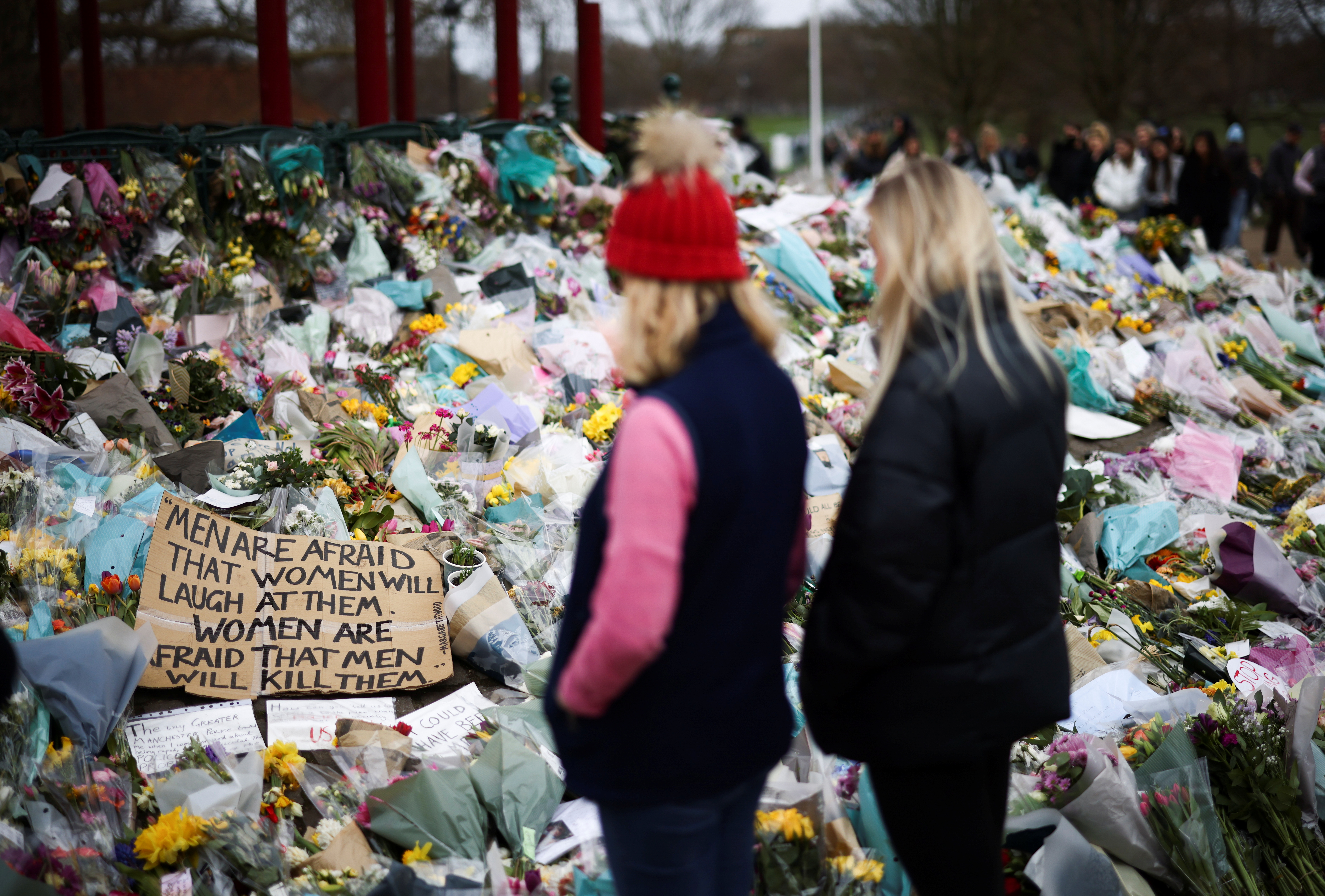 People observe a memorial site at the Clapham Common Bandstand, following the kidnapping and murder of Sarah Everard, in London