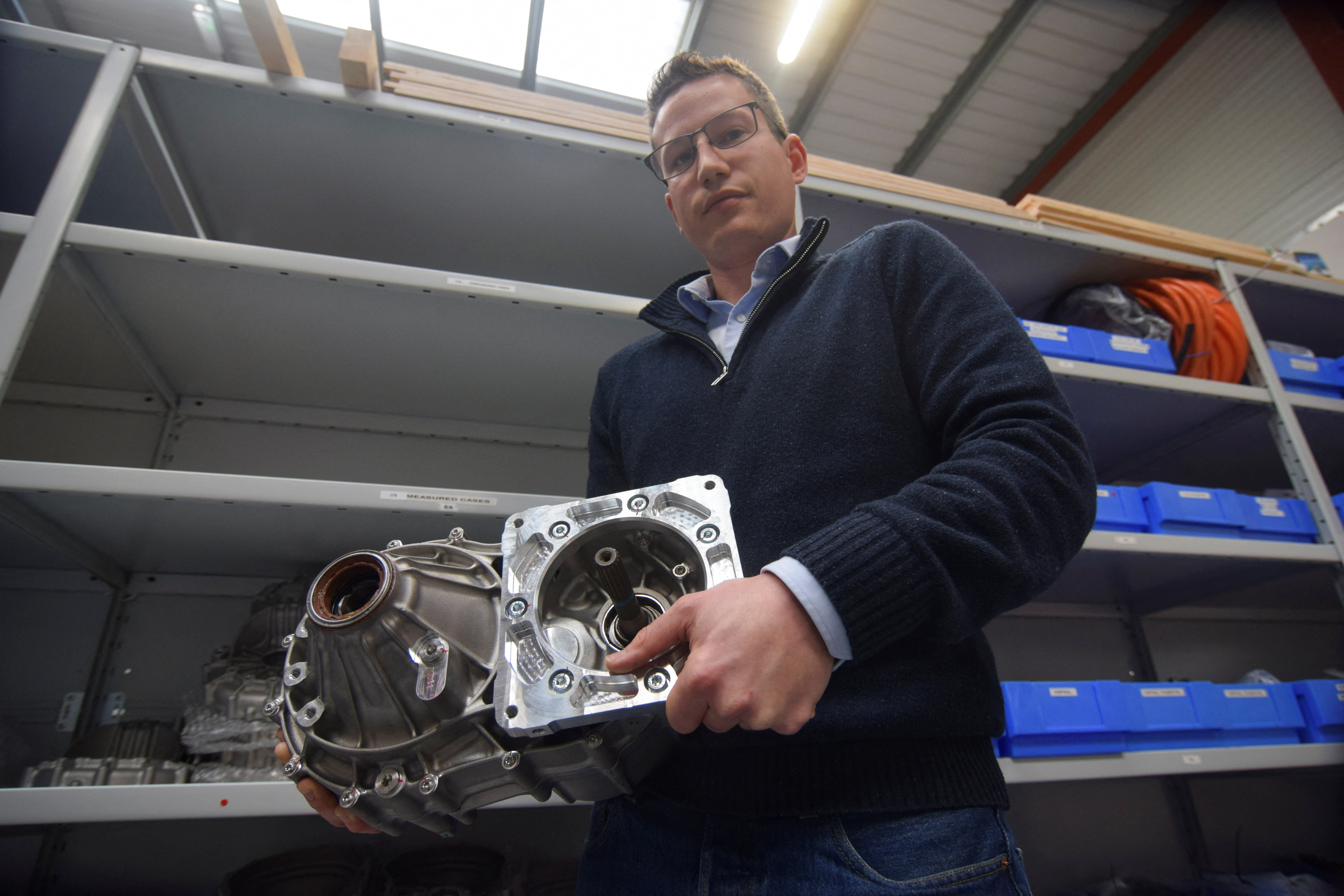 John Bond, commercial manager of motorsport engine maker Swindon Powertrain, holds a part of an e-axle the company has developed, in Swindon