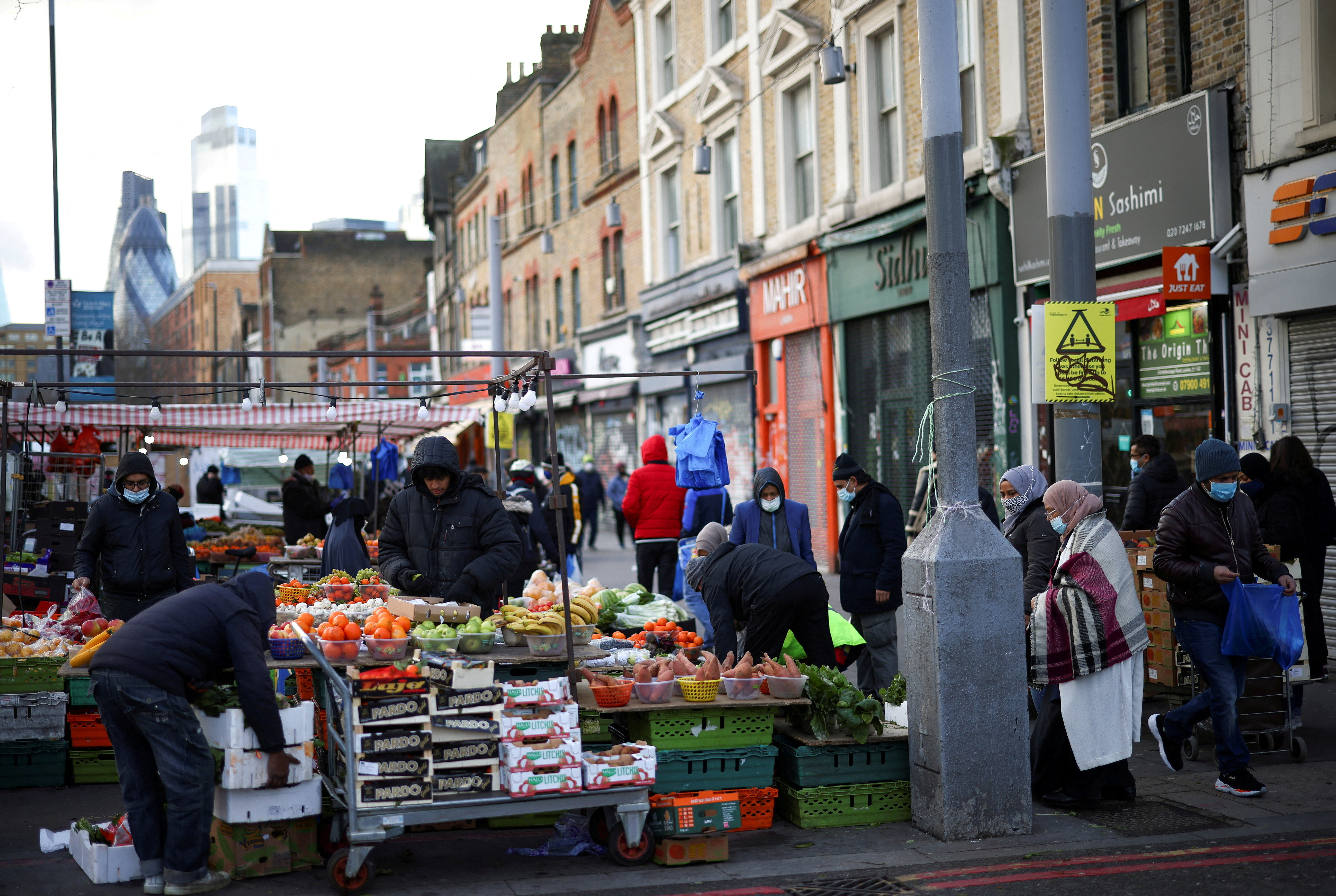 People shop at a market stalls in east London