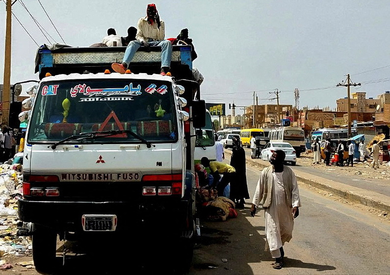 People gather to ride trucks to flee outside Khartoum, in South Khartoum locality