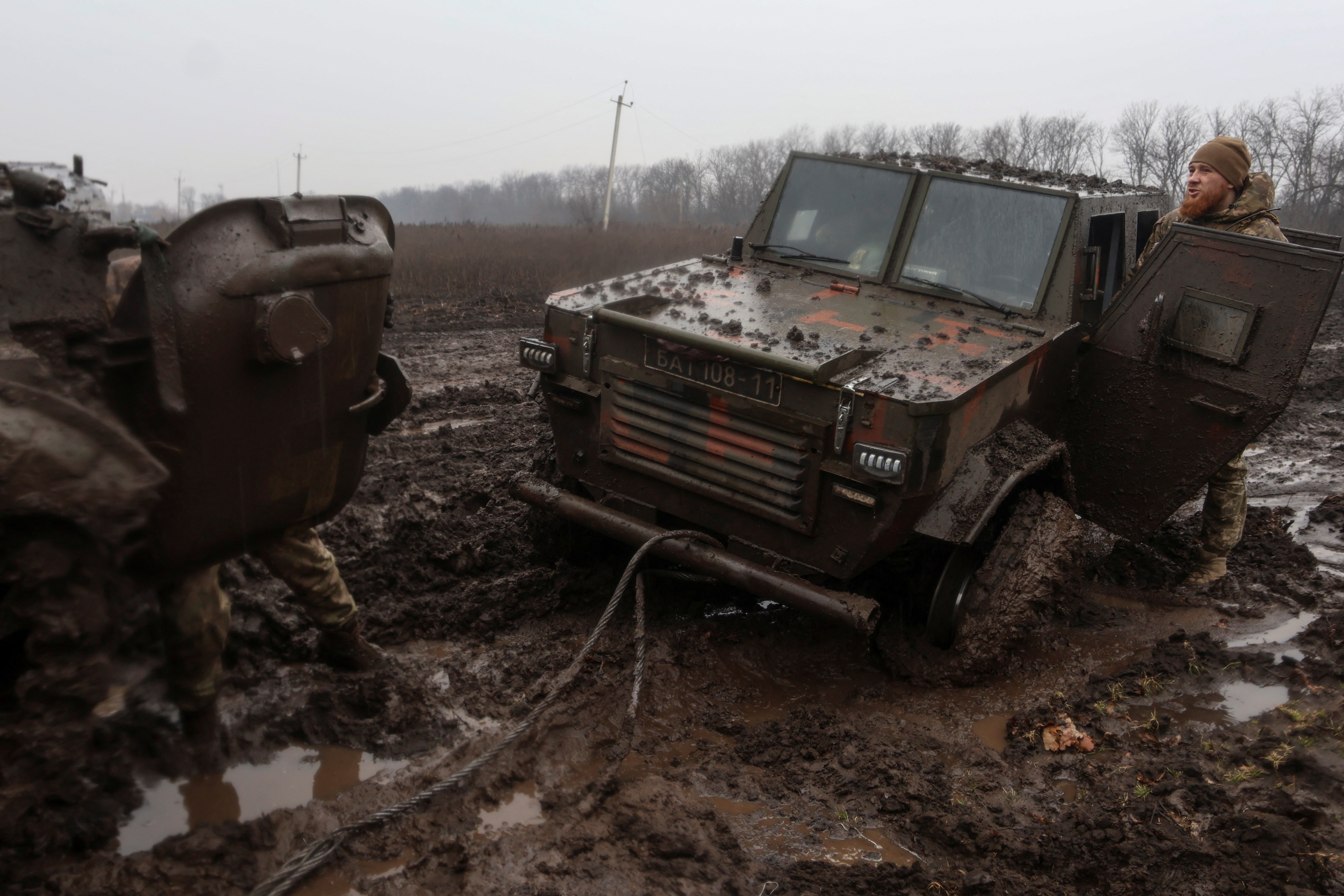 Ukrainian service members are seen next to armoured vehicles near the frontline town of Bakhmut