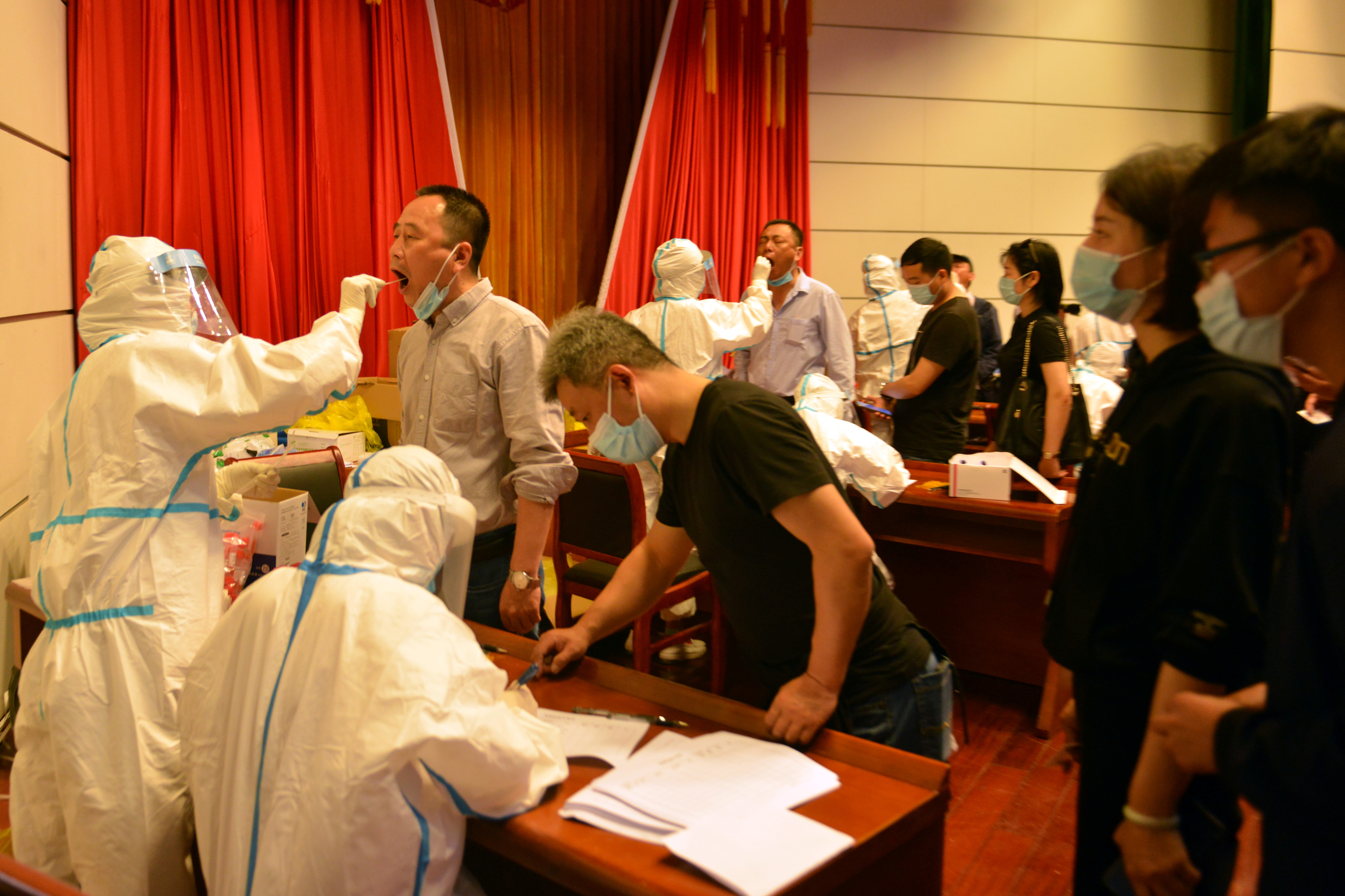 Medical workers collect swabs from residents following new cases of the coronavirus disease (COVID-19), at a nucleic acid test site in Luan, Anhui