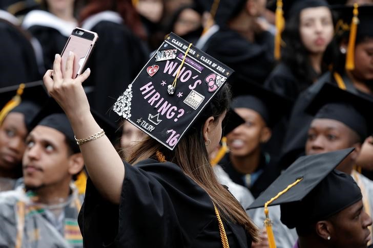 A graduating student of the CCNY takes a selfie of the message on her cap during the College's commencement ceremony in the Harlem section of Manhattan, New York