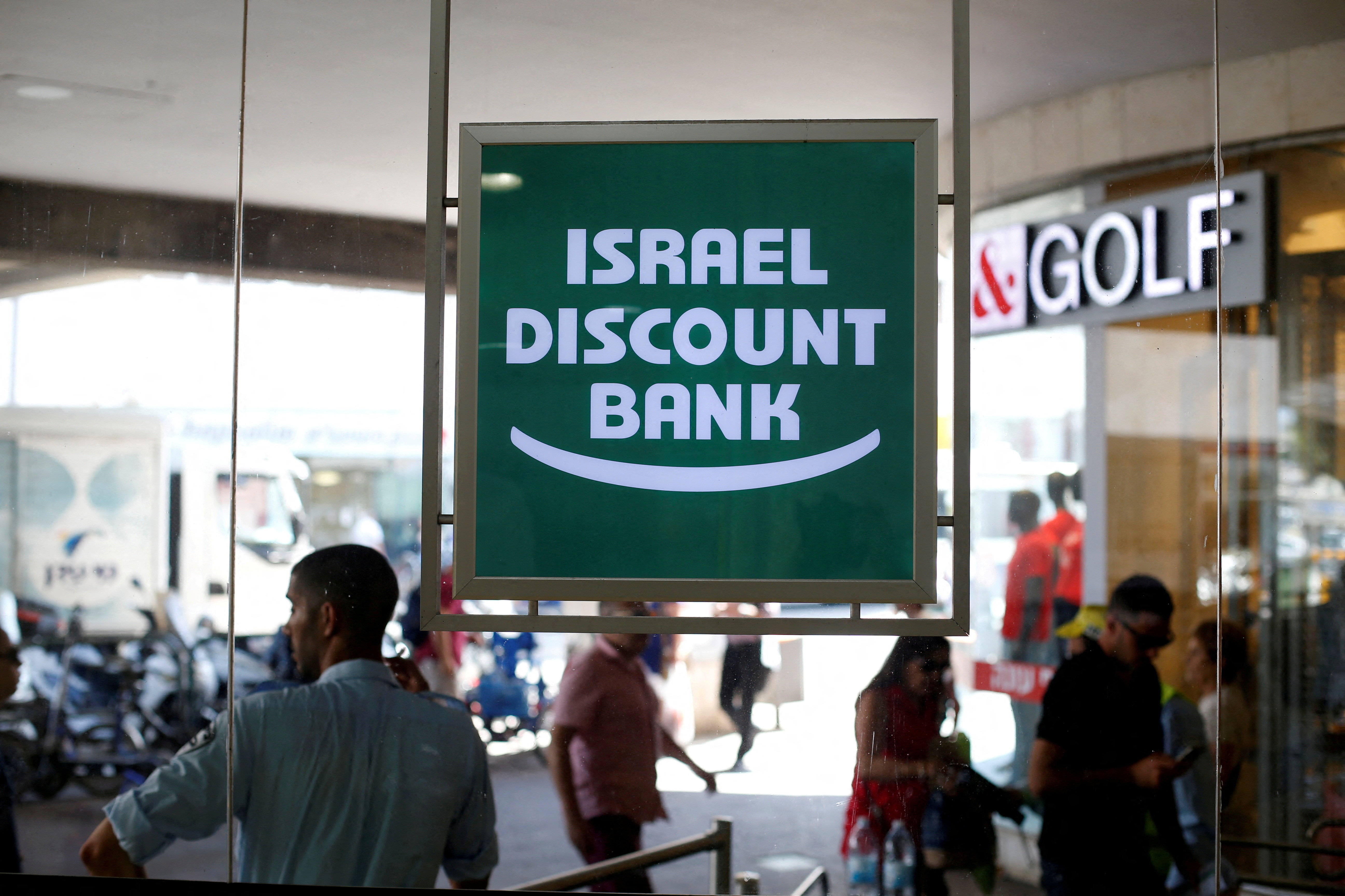 FILE PHOTO: The logo of Israel Discount Bank is reflected in mirrors outside their branch in Tel Aviv, Israel
