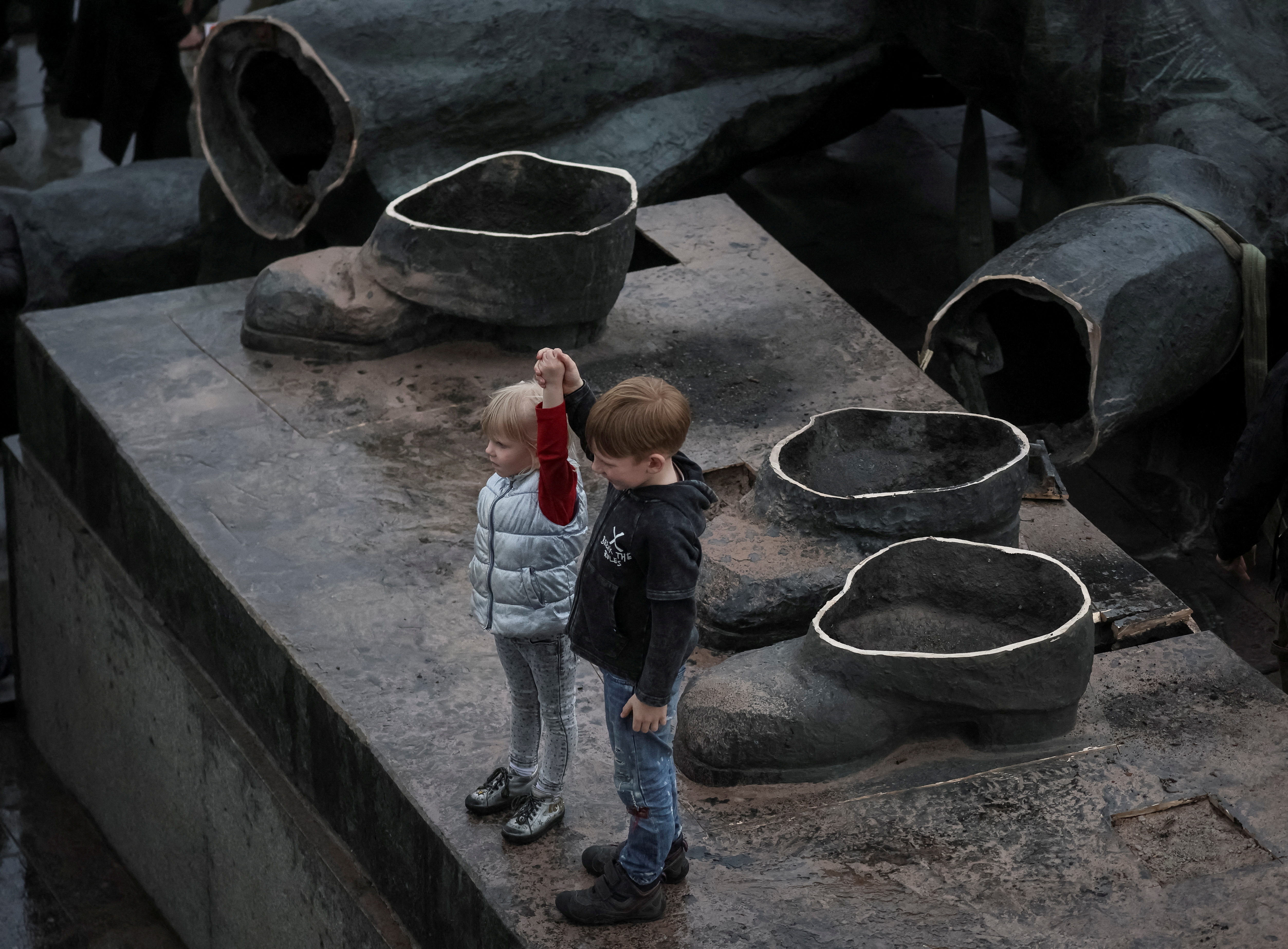 کودکان بنای یادبود اتحاد جماهیر شوروی را به دوستی بین کشورهای اوکراین و روسیه پس از تخریب آن در مرکز کیف به تصویر می کشند