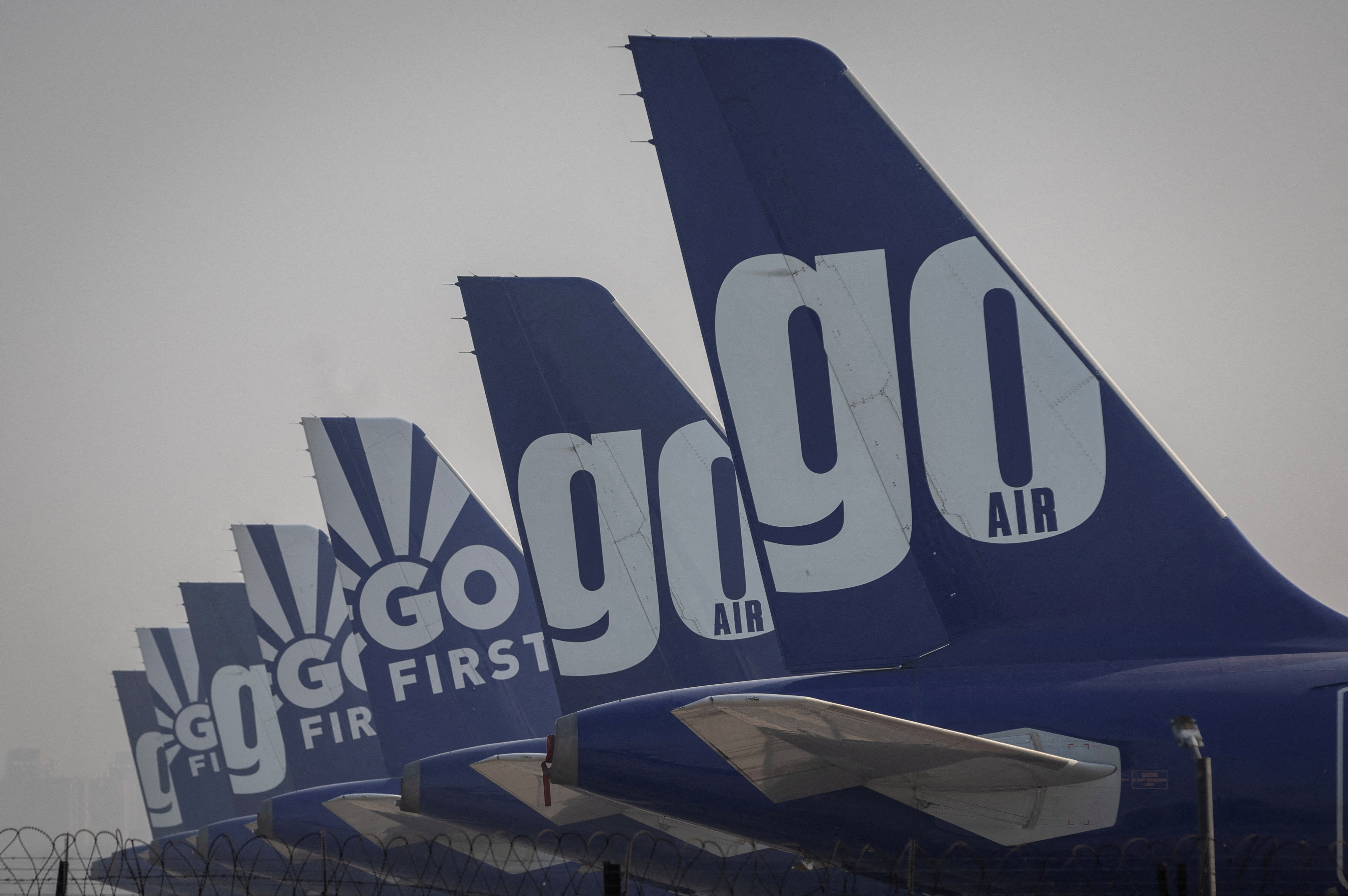 The tail fins of Go First airline, formerly known as GoAir, passenger aircrafts are seen parked on the tarmac at the airport in New Delhi