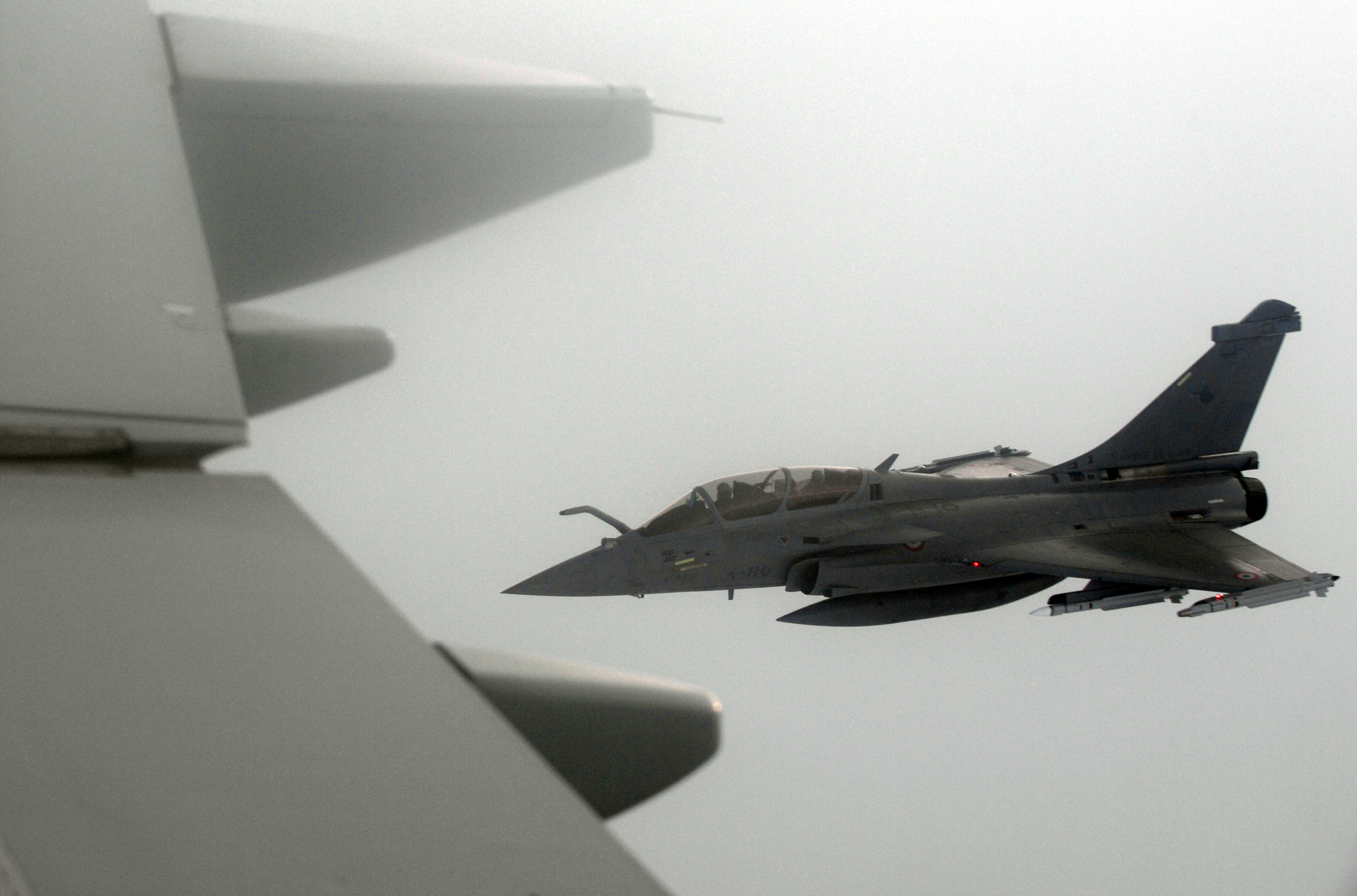 A French Rafale fighter jet demonstrates the interception of a Belgian air force transport plane as they fly over France