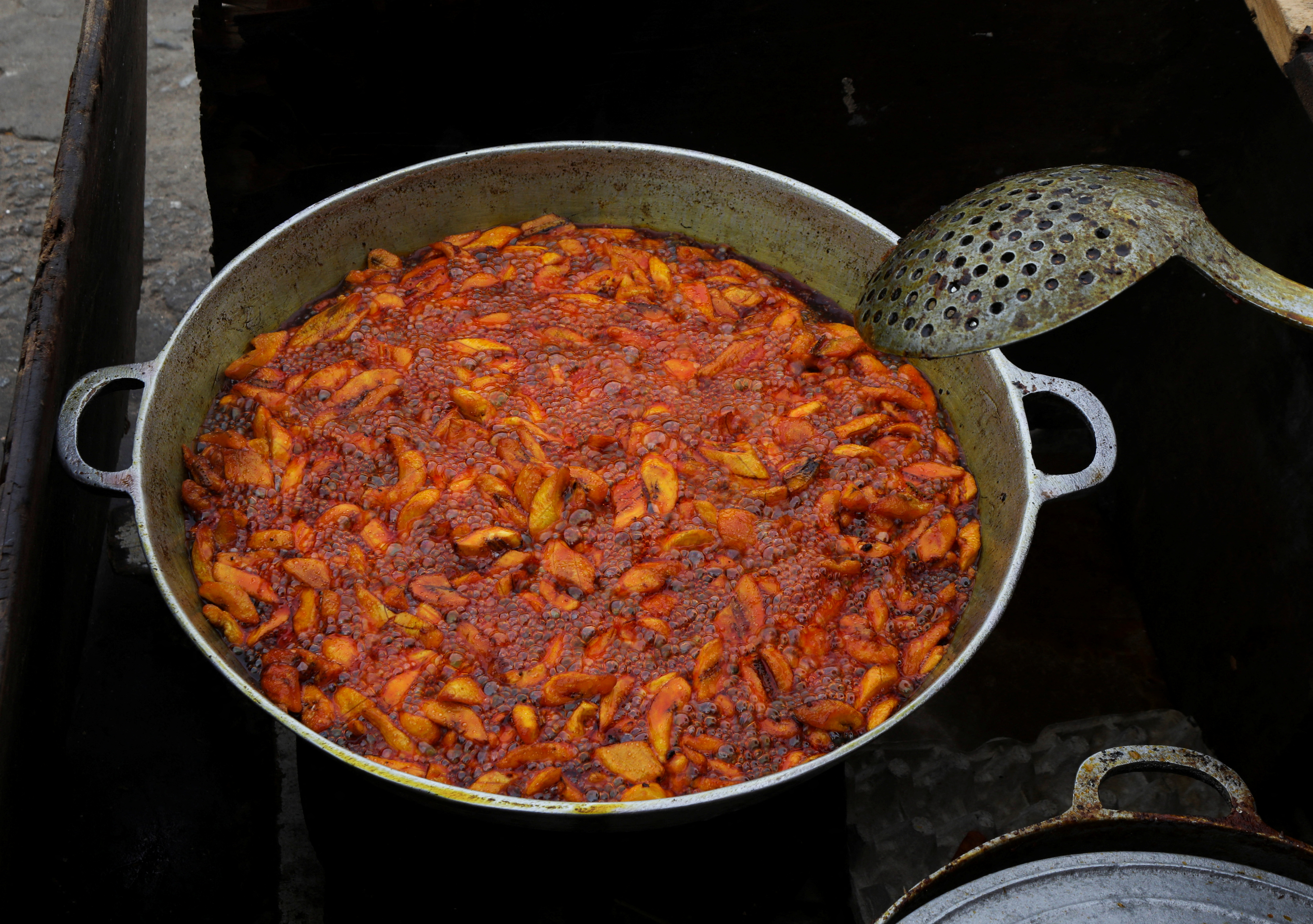 Plantains fried in a crude palm oil, are seen on the stand of a street vendor in Abidjan