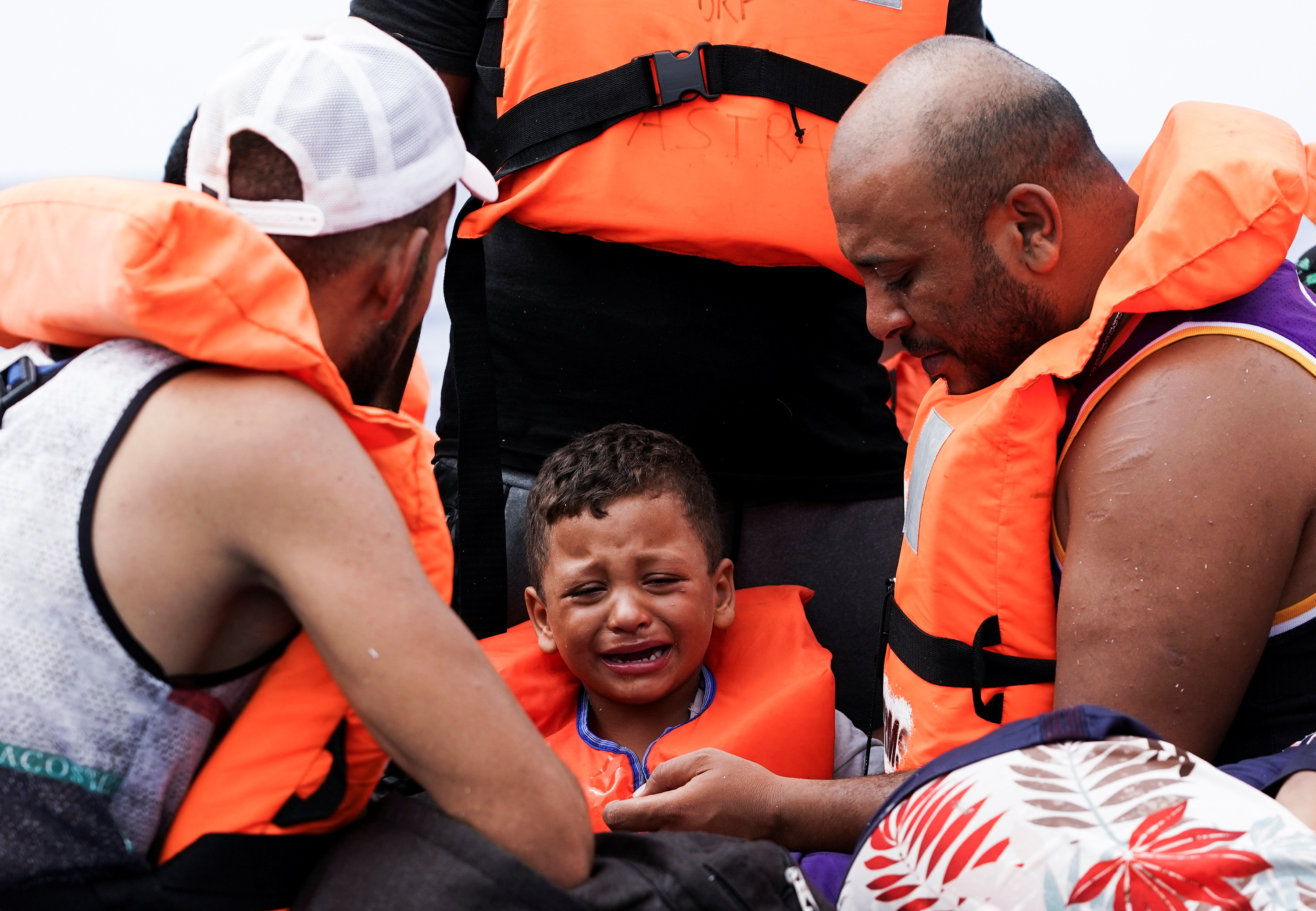 A boy cries on board a wooden boat as they waiting for the Italian Guardia Costiera near the island of Lampedusa, in the Mediterranean Sea, September 1, 2021. REUTERS/Juan Medina
