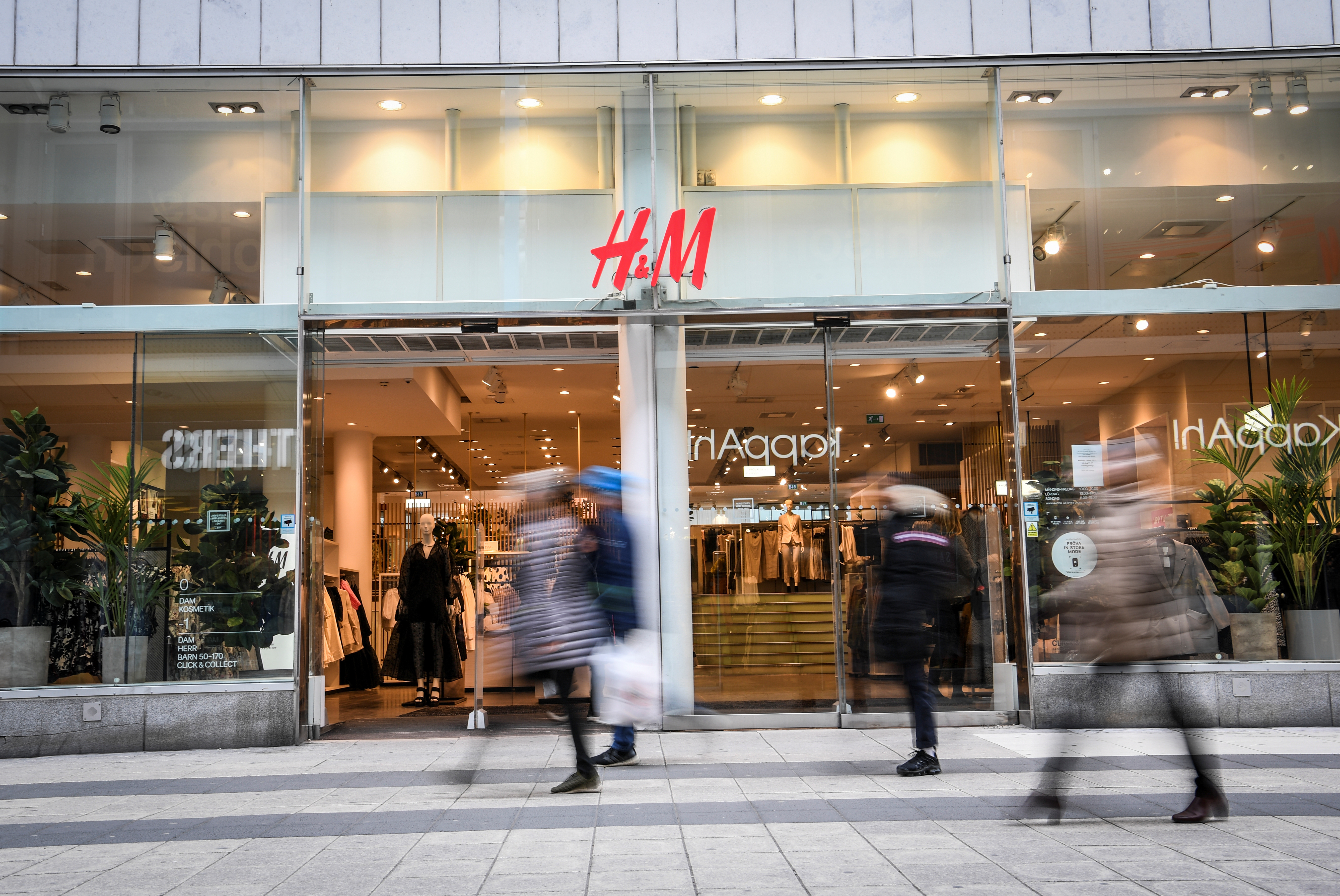 People walk past an H&M store in Stockholm