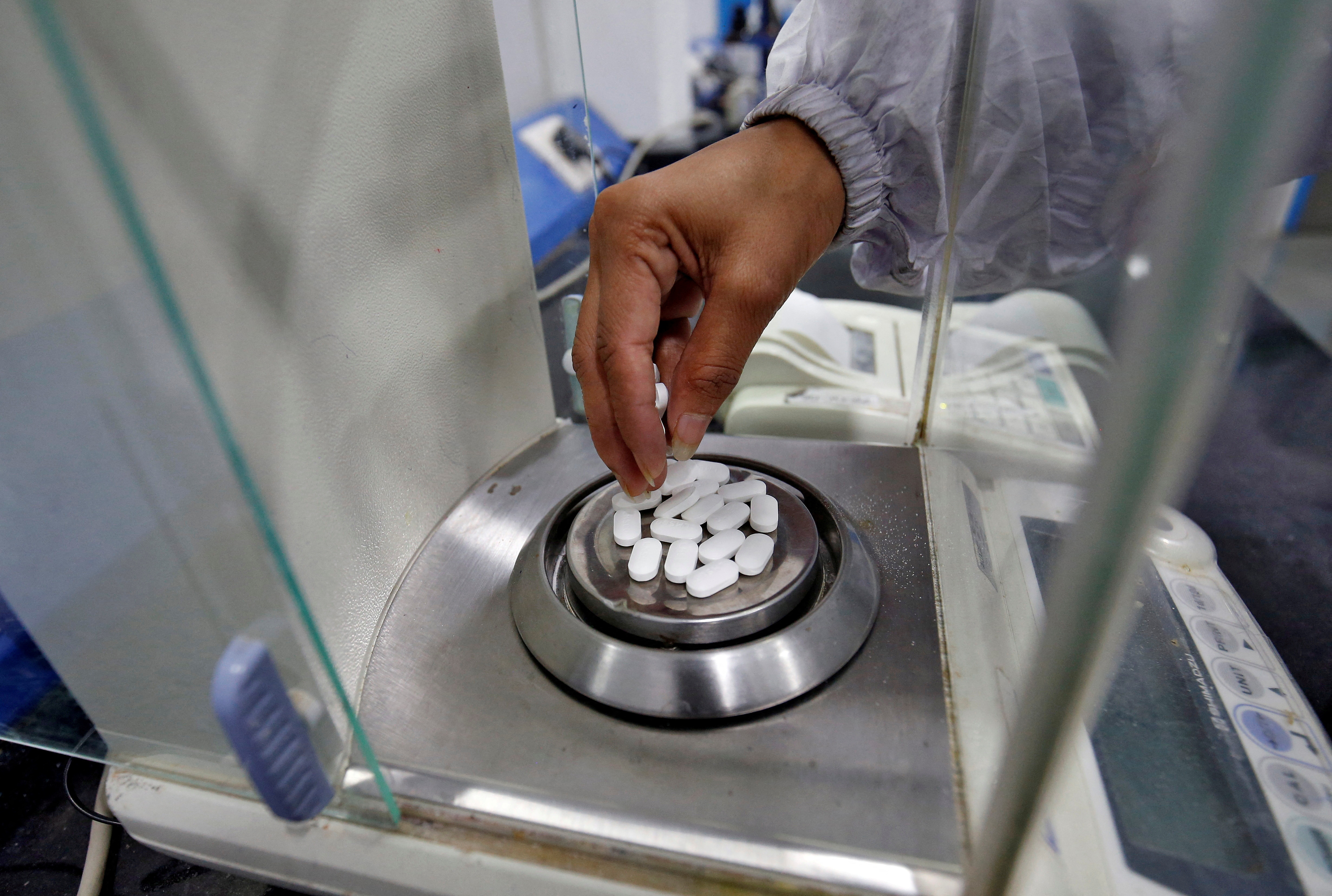 A pharmacist checks weight of paracetamol tablets inside a lab of a pharmaceutical company on the outskirts of Ahmedabad