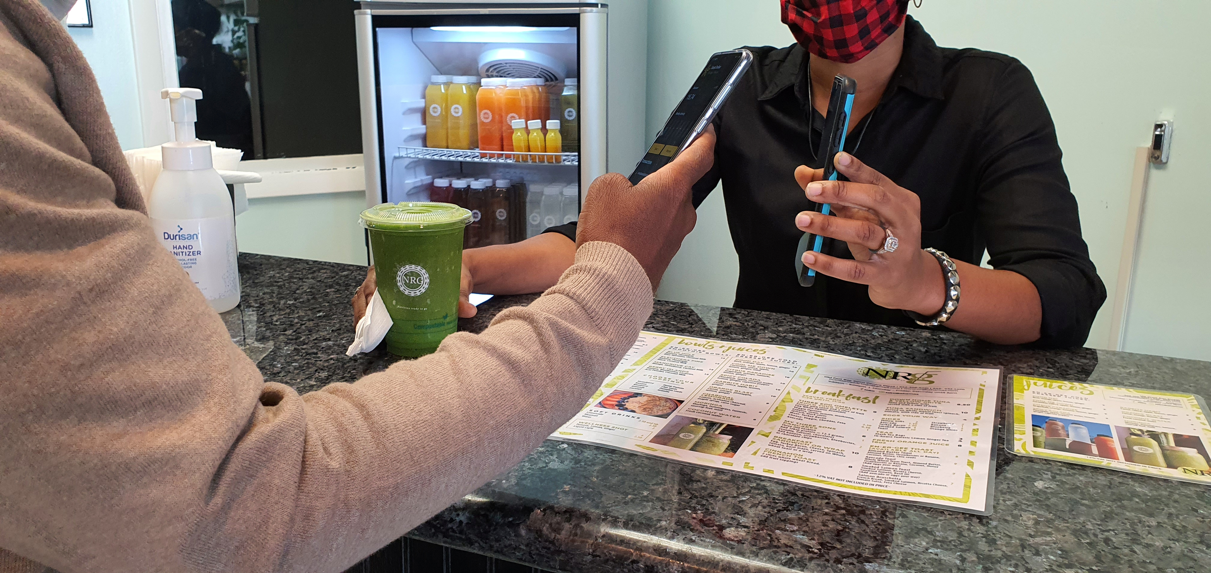 Dawn Sands, owner of NRG cafe, takes payment from a customer with central bank digital currency in Nassau, the Bahamas in November 2020 in this handout image obtained by Reuters on December 17, 2020. Central Bank of The Bahamas (CBoB)/Handout via REUTERS