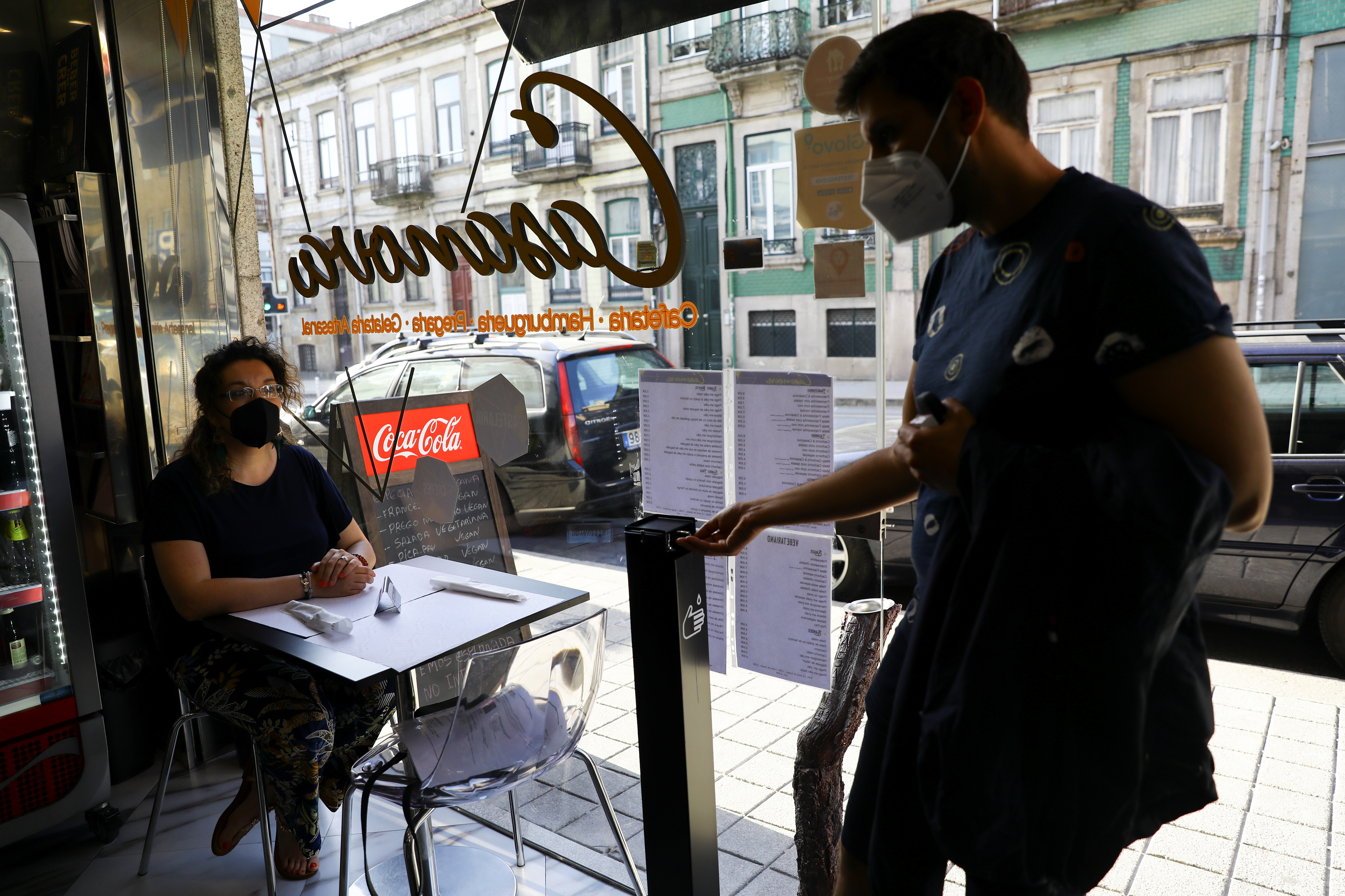 A woman sits in a restaurant, on the day that Portugal's government imposed stricter rules in an attempt to bring under control a surge of coronavirus disease (COVID-19) cases, in Porto, Portugal, July 10, 2021. REUTERS/Violeta Santos Moura