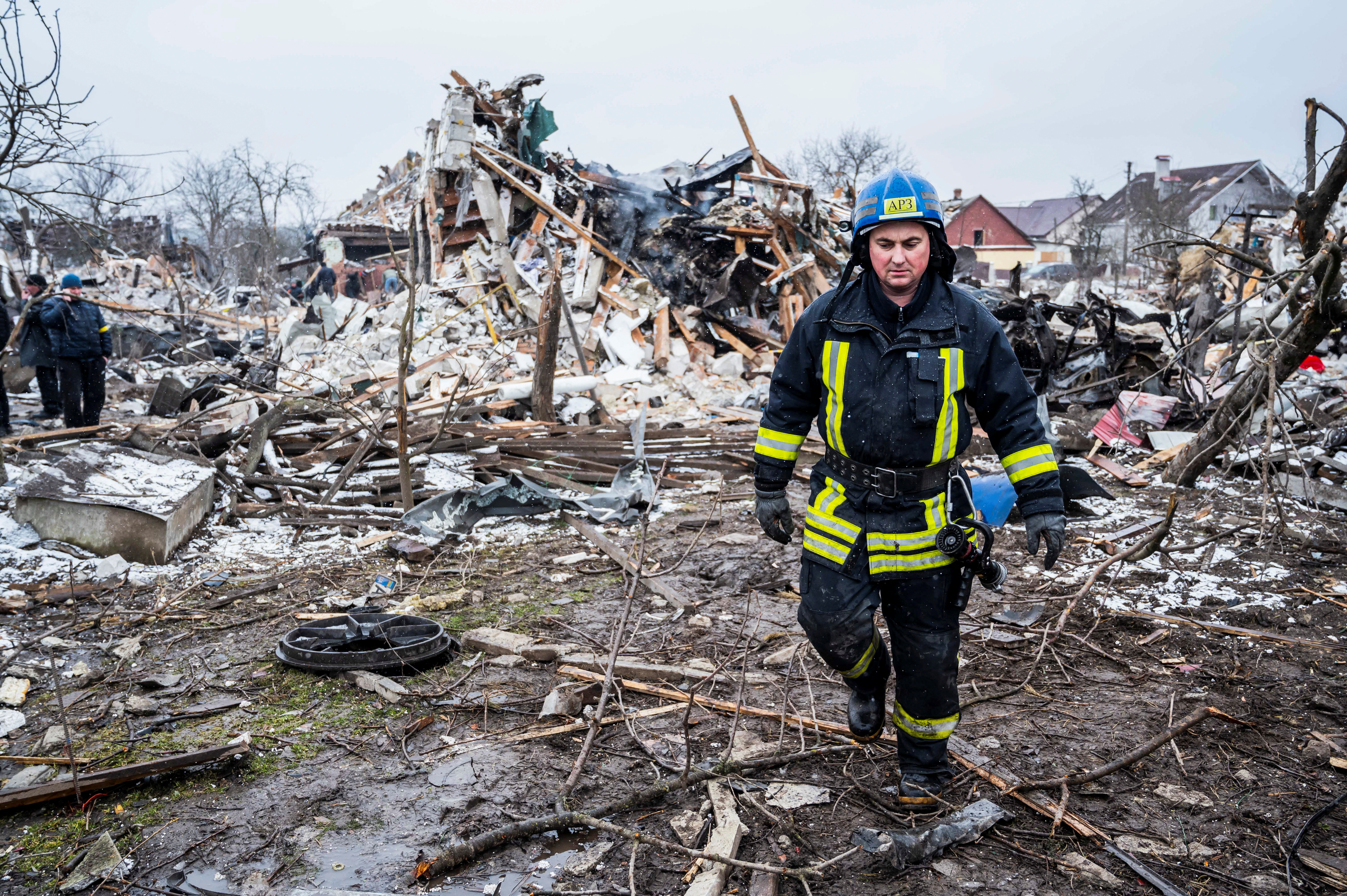 A rescuer walks among debris of residential buildings destroyed by shelling, as Russia's invasion of Ukraine continues, in Zhytomyr