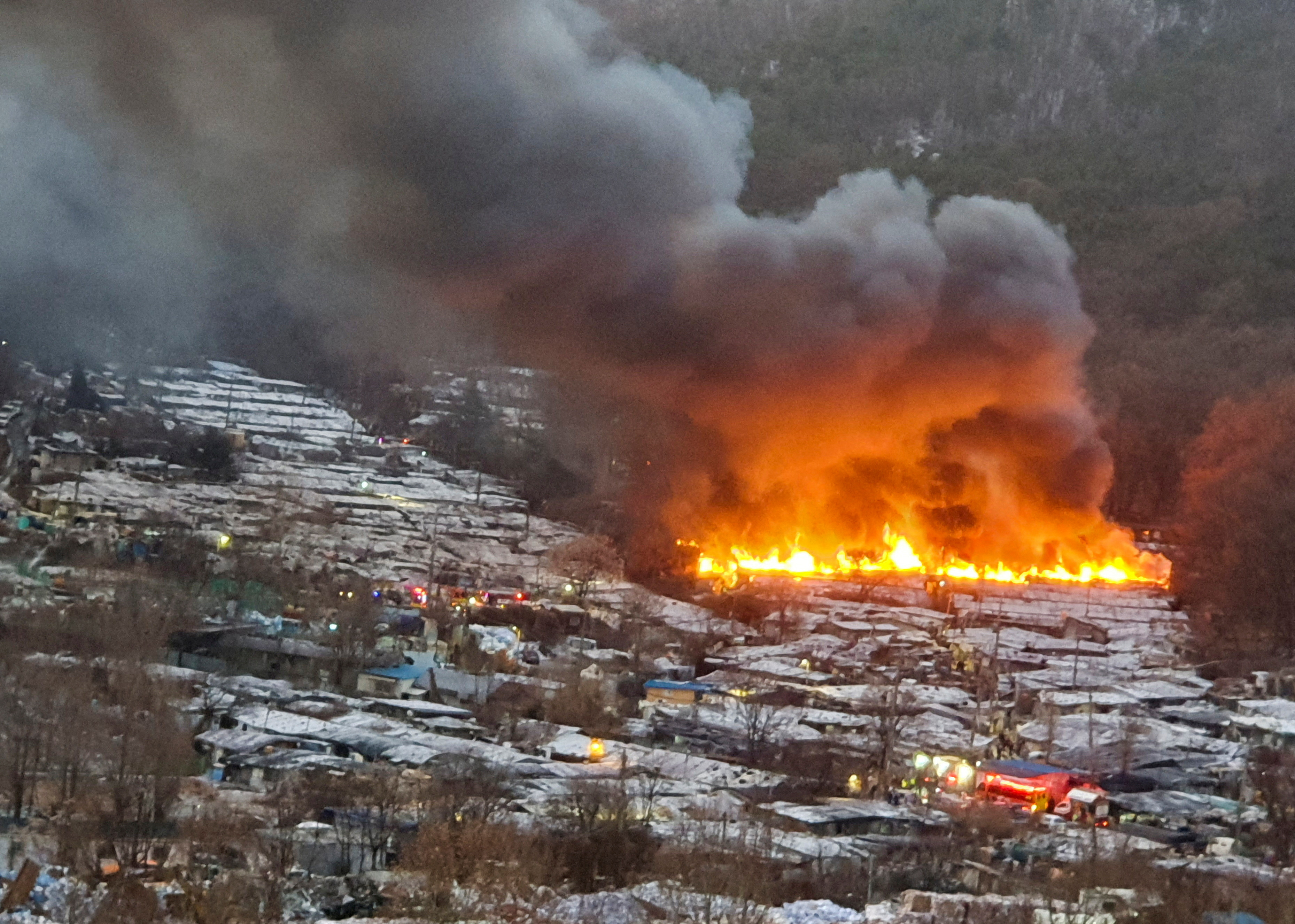 Rook stijgt op bij een brand in het dorp Guryong in Seoul