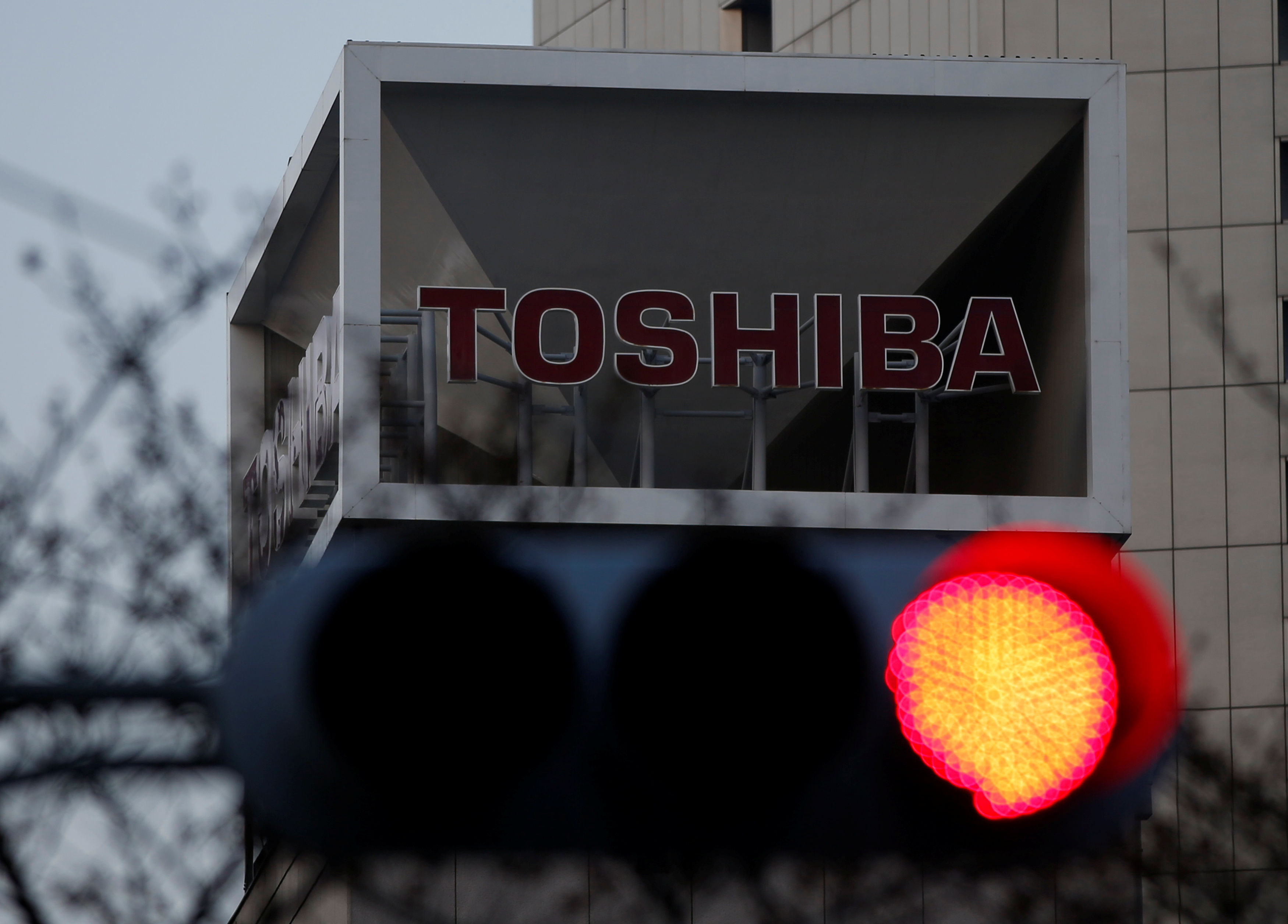 The logo of Toshiba Corp is seen behind a traffic light at the company's headquarters in Tokyo
