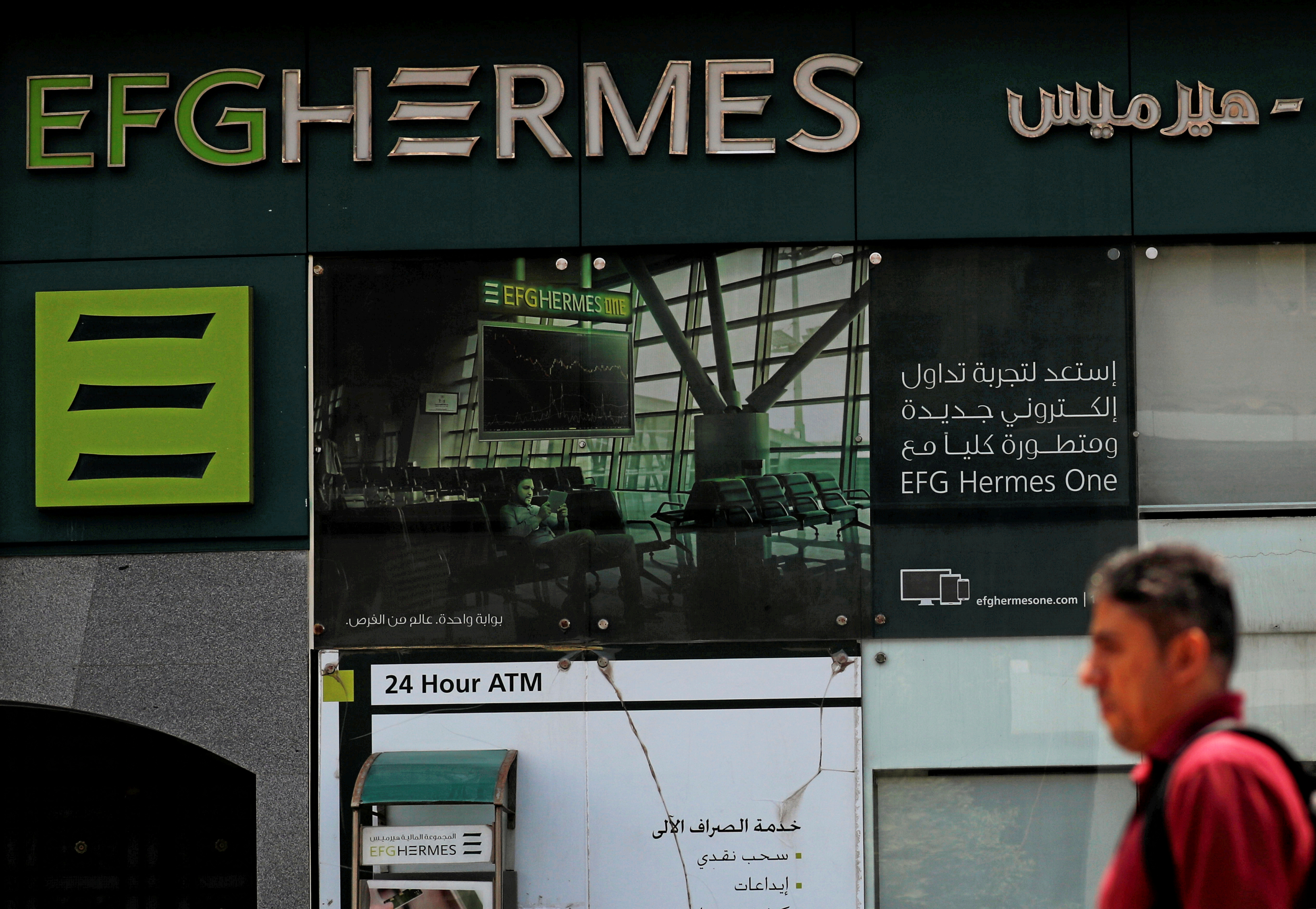 An Egyptian man walks past a branch of the EFG Hermes investment bank in Cairo