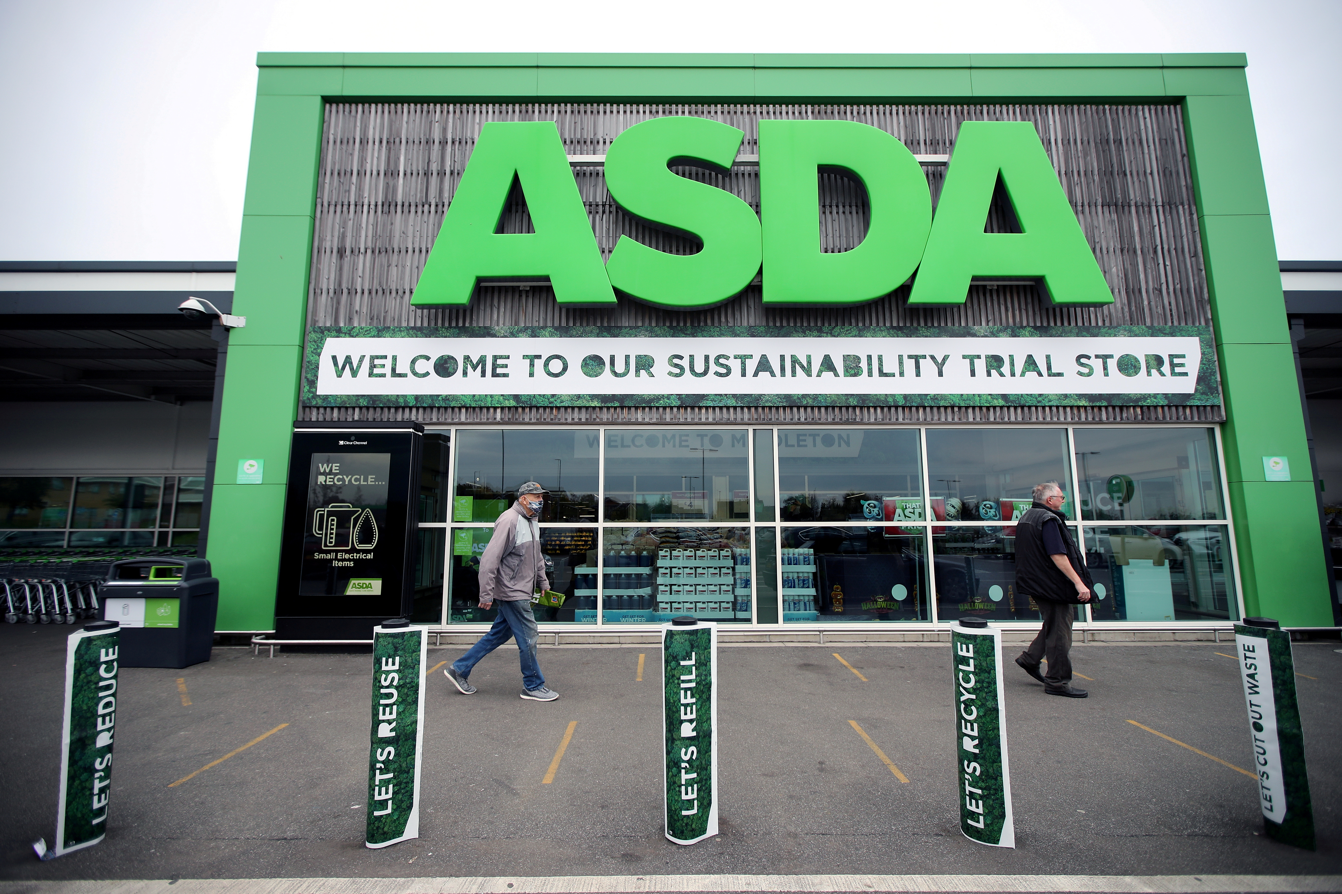 Shoppers walk past the UK supermarket Asda, as the store launches a new sustainability strategy, in Leeds