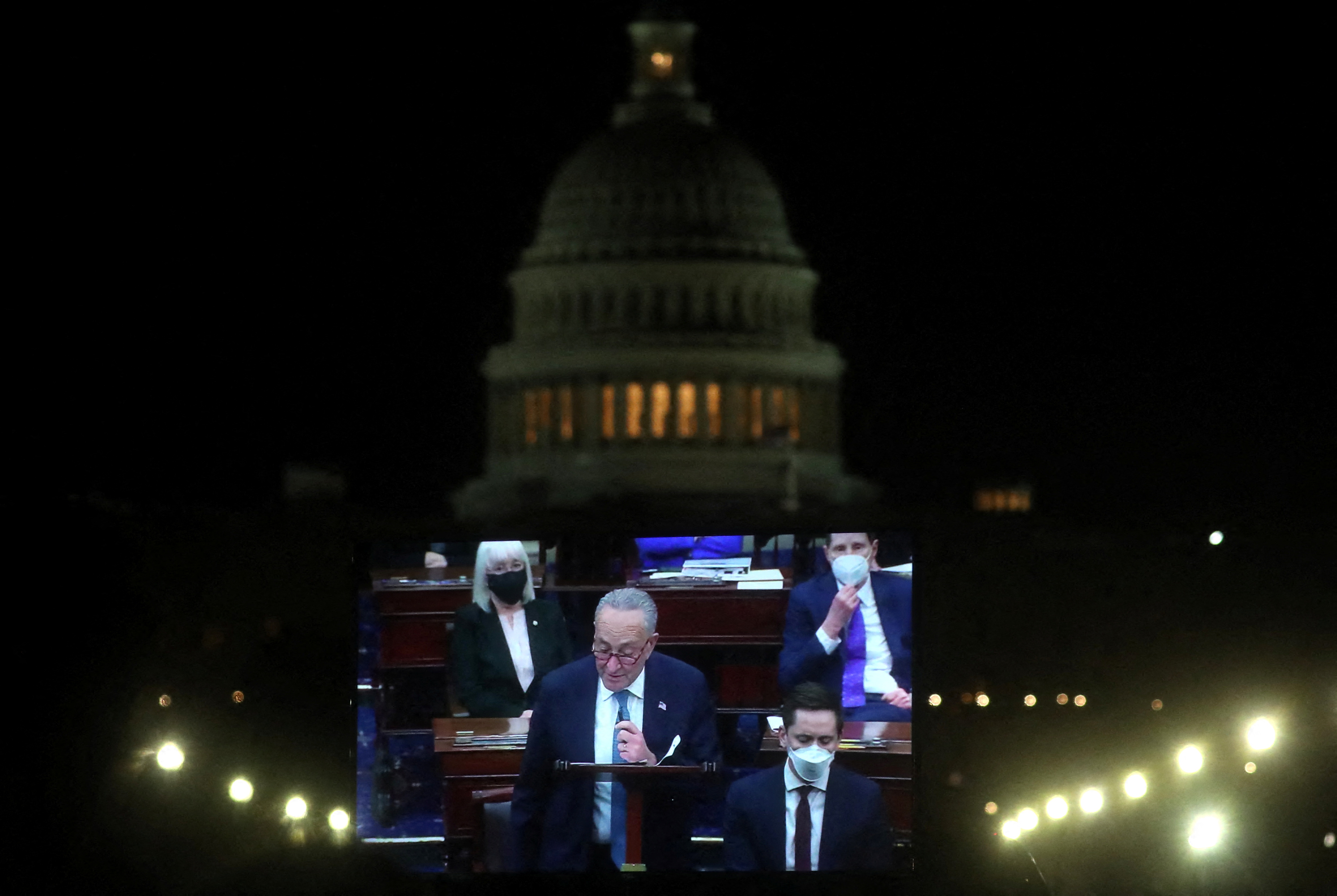 U.S. Senate Majority Leader Chuck Schumer (D-NY) is projected live on a screen as he takes part in the debate from U.S. Senators of voting rights legislation near the U.S. Capitol building in Washington, U.S., January 19, 2022. REUTERS/Leah Millis