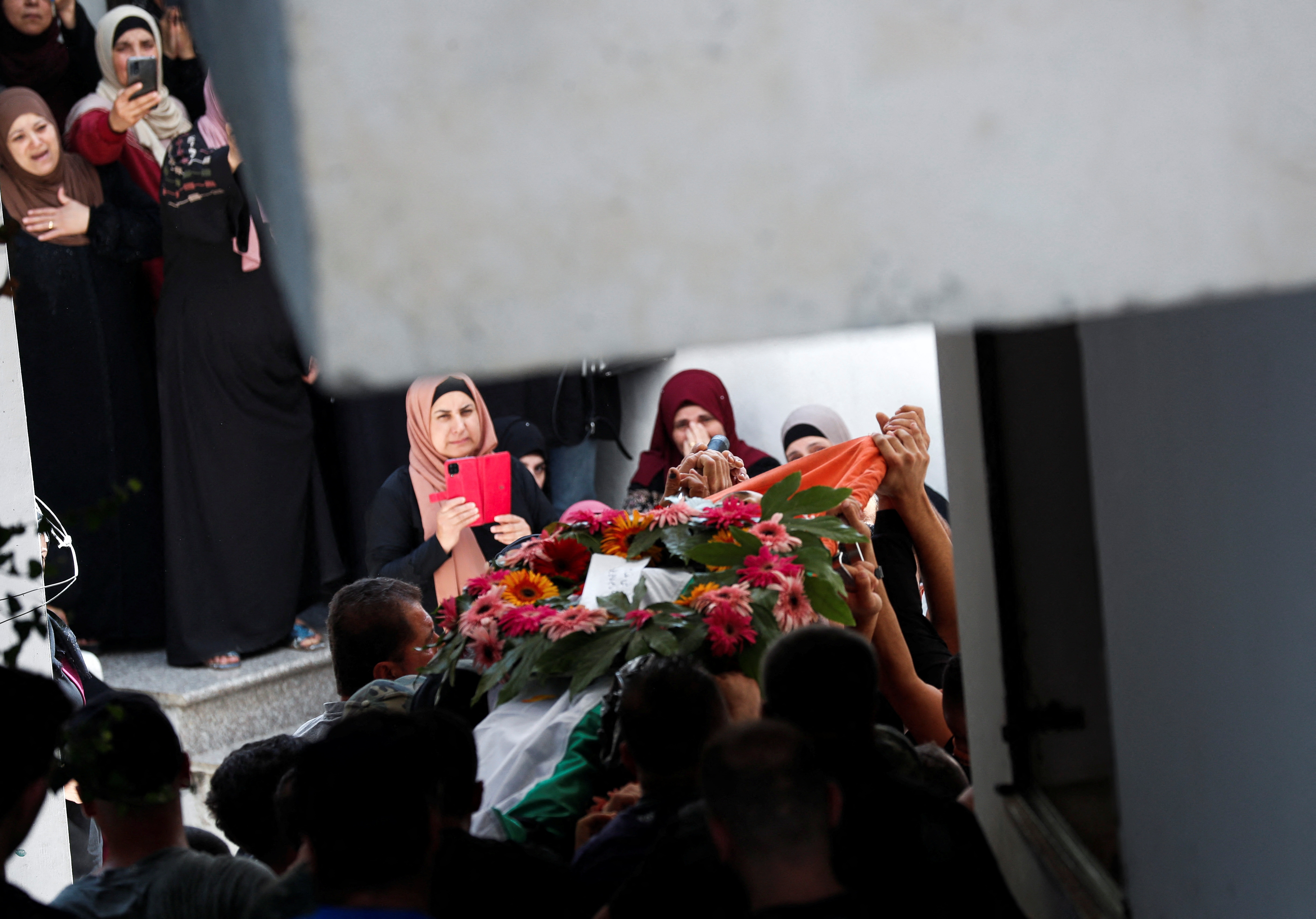 People react after Palestinian Yazan Afanah was killed during an Israeli raid in Qalandiya