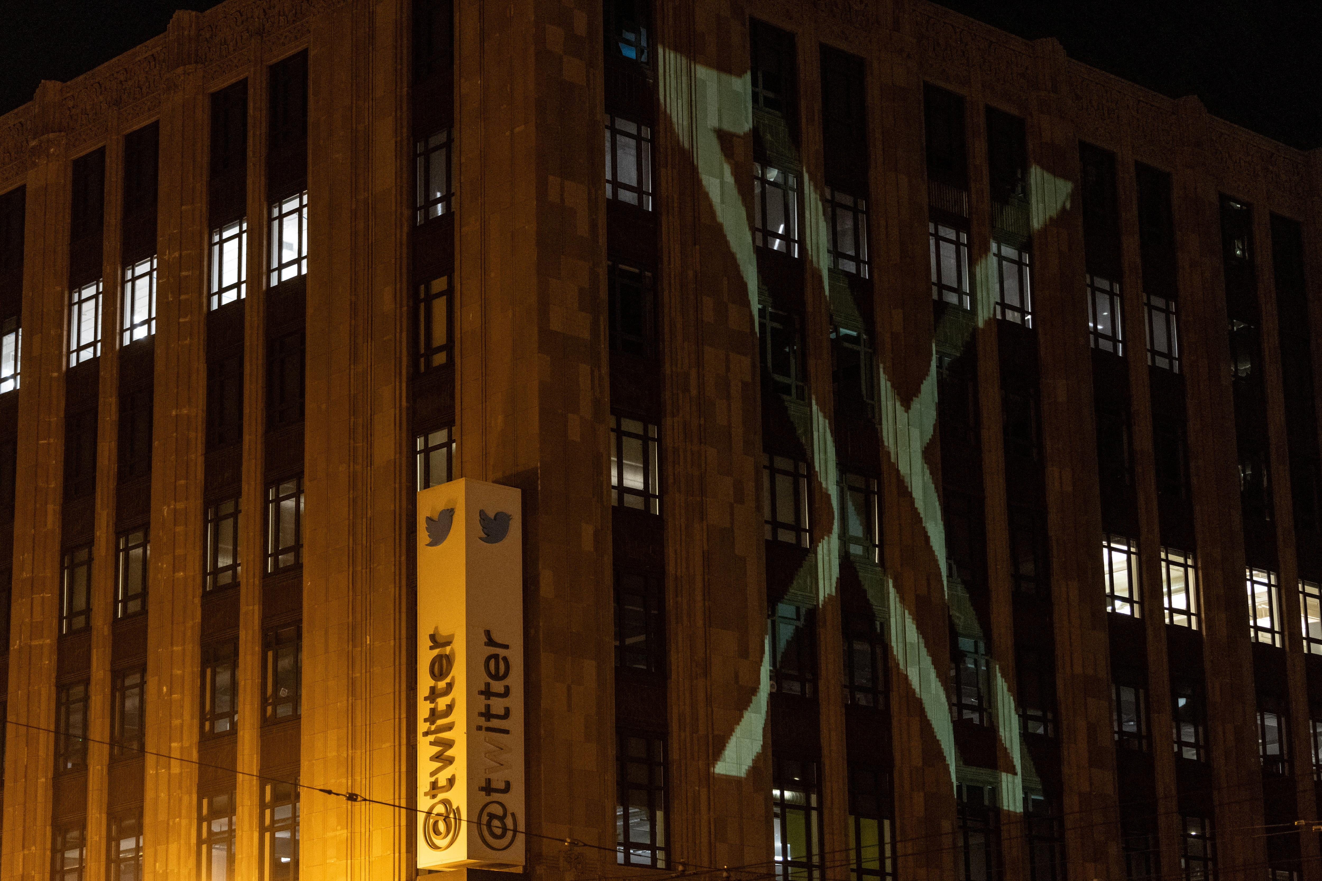 Twitter's new logo is seen projected on the corporate headquarters building in downtown San Francisco, California