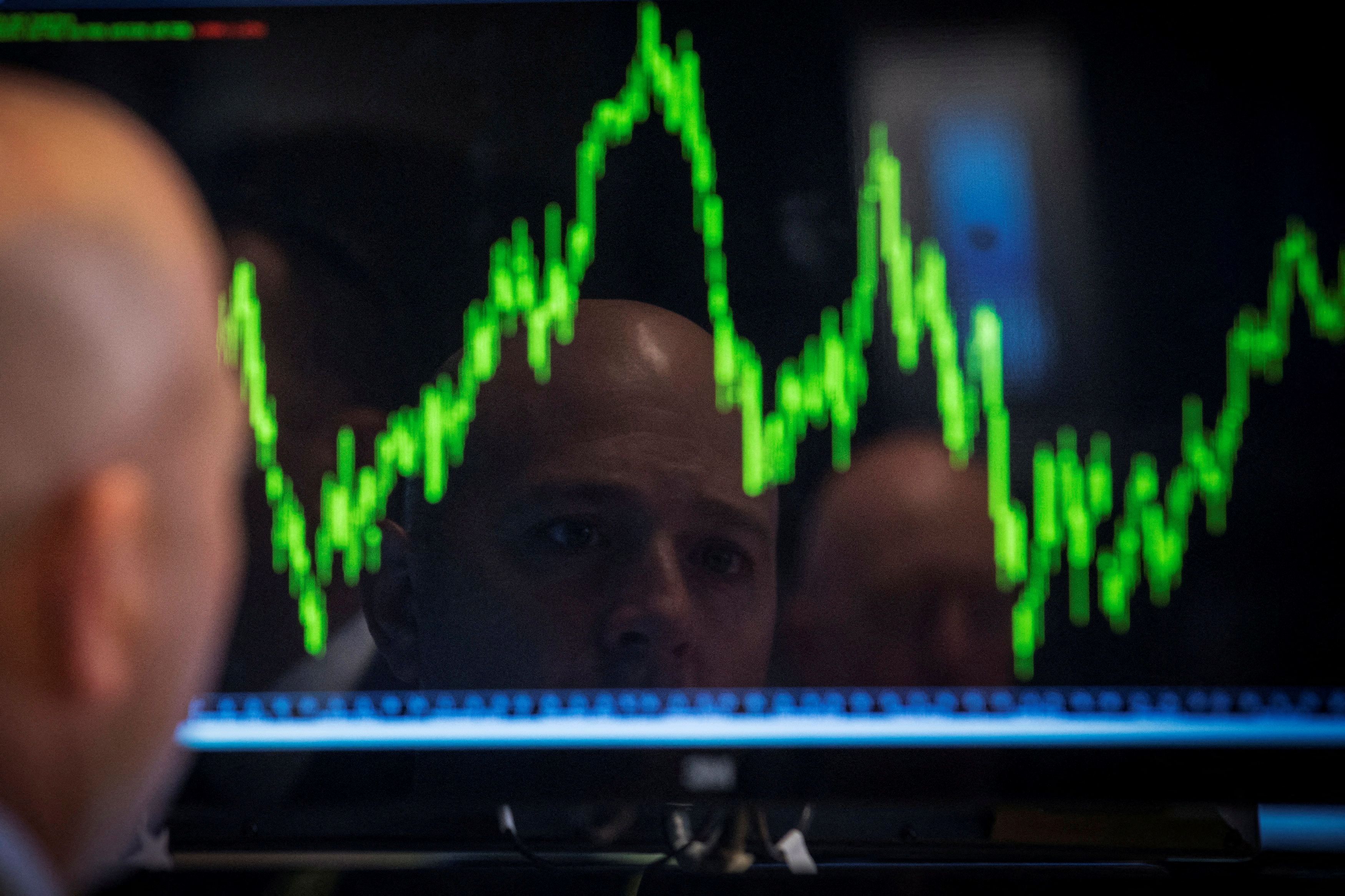 A trader watches his chart while working on the floor of the New York Stock Exchange