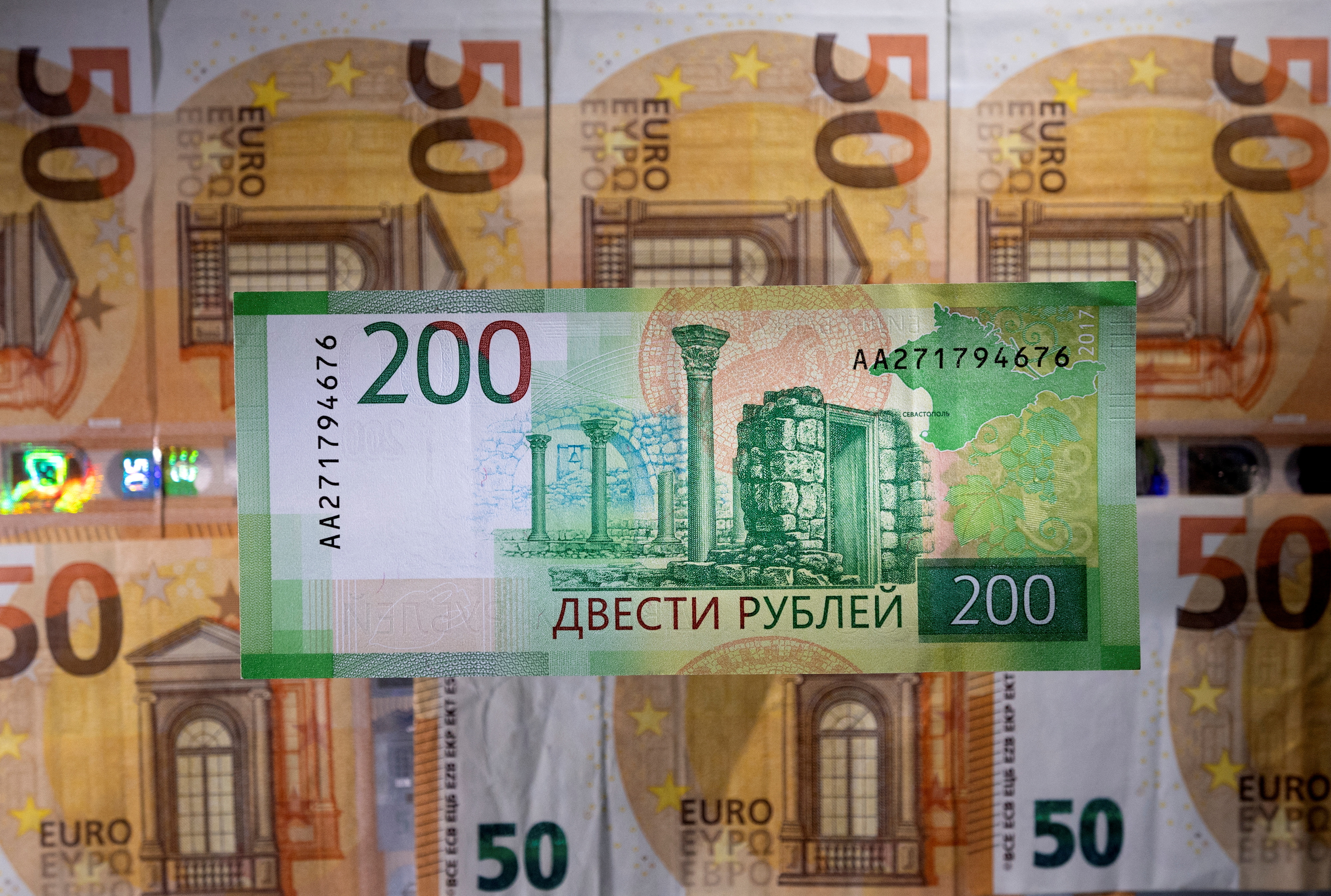 Illustration shows a Russian rouble banknote placed on euro banknotes